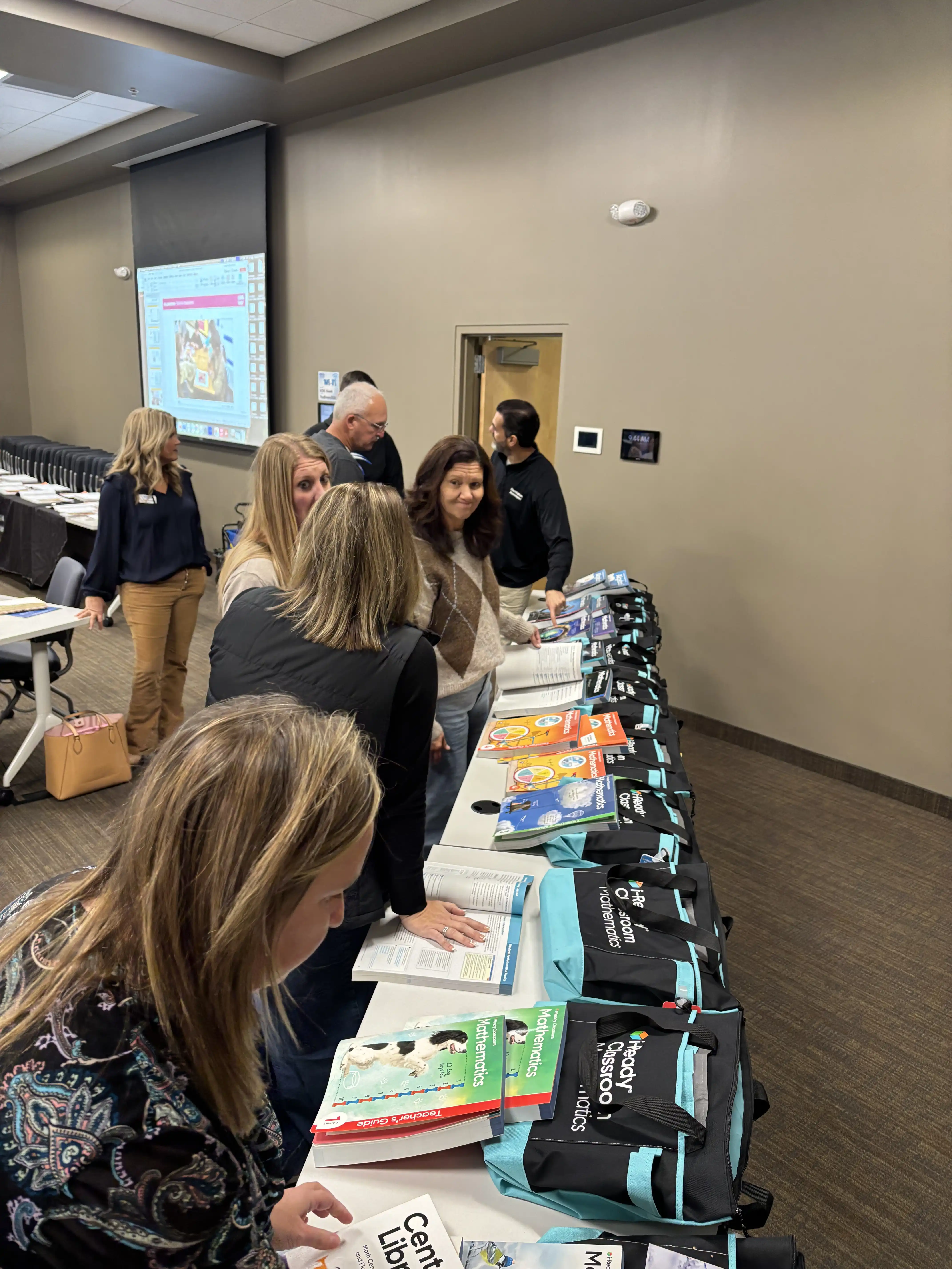 teachers looking at a table of math book resources