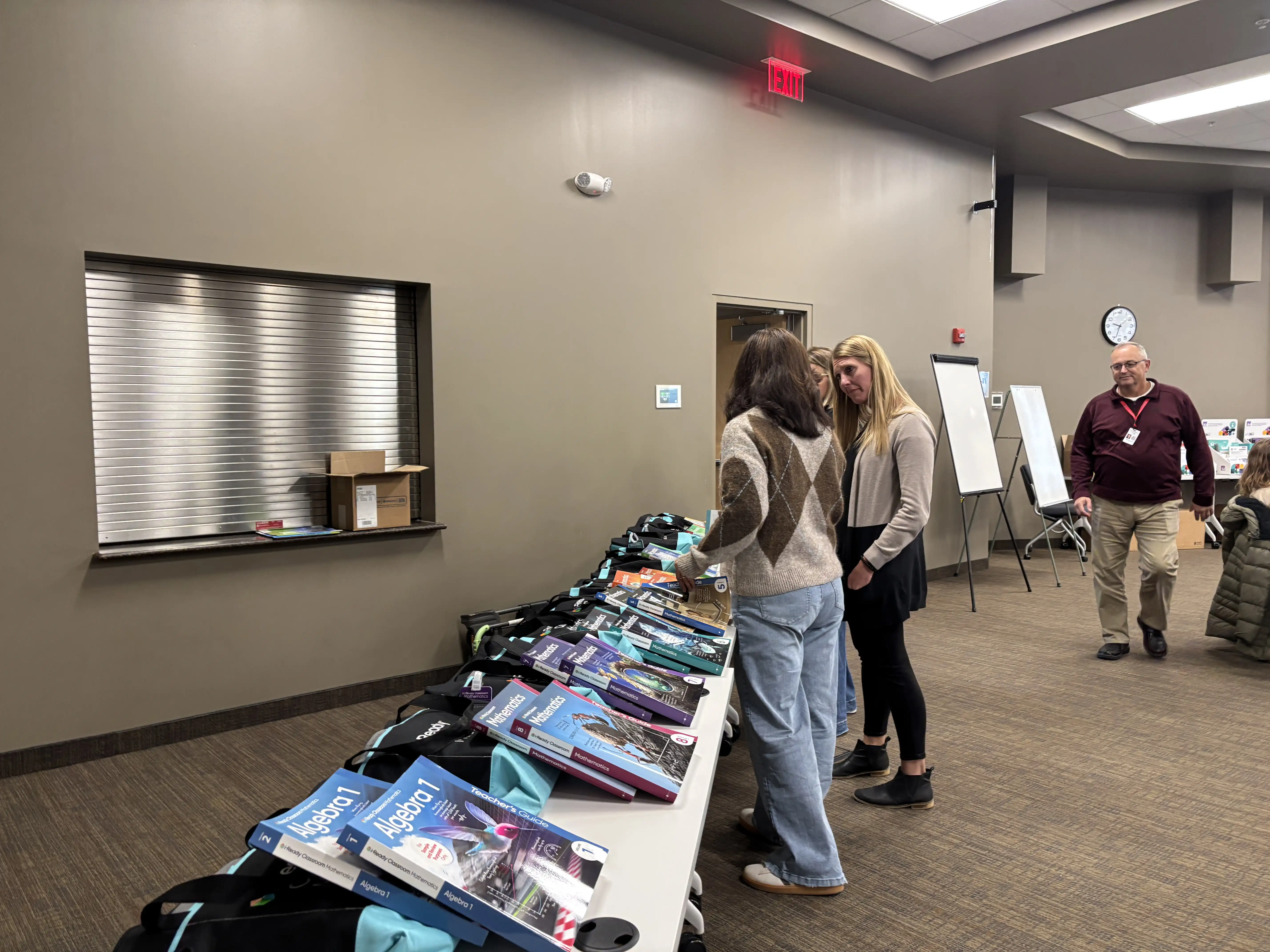 teachers walking by a table looking at various math resources