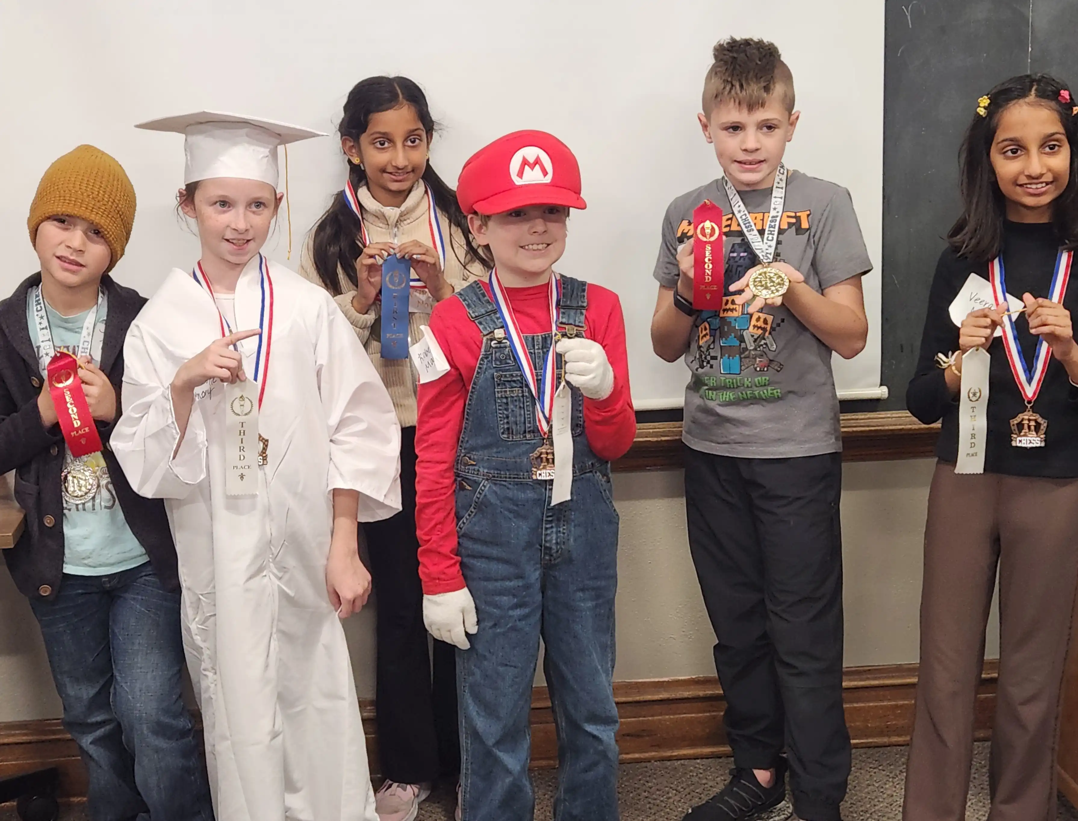 6 students standing with their chess ribbons on.