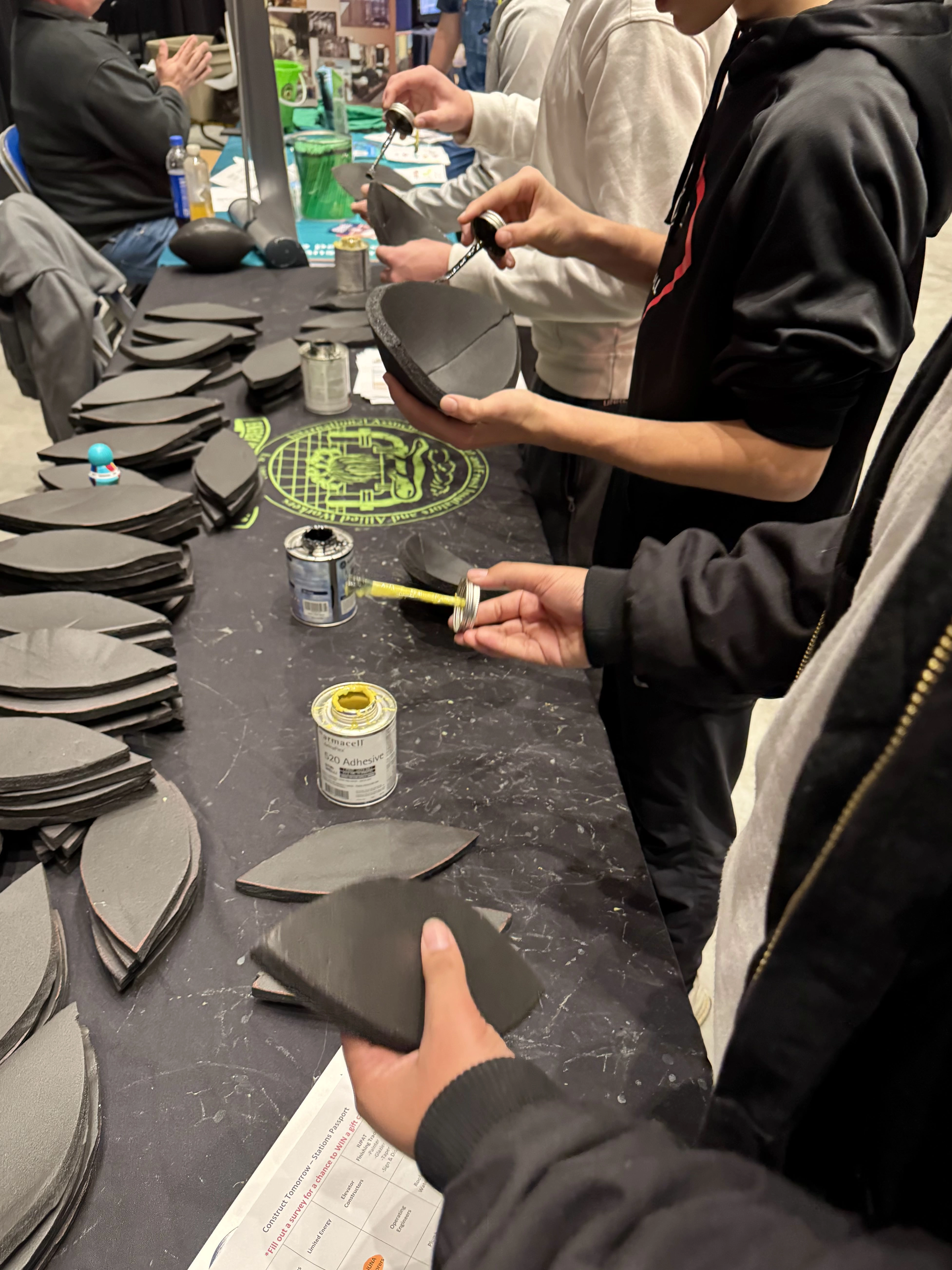 students at a booth gluing together natural materials
