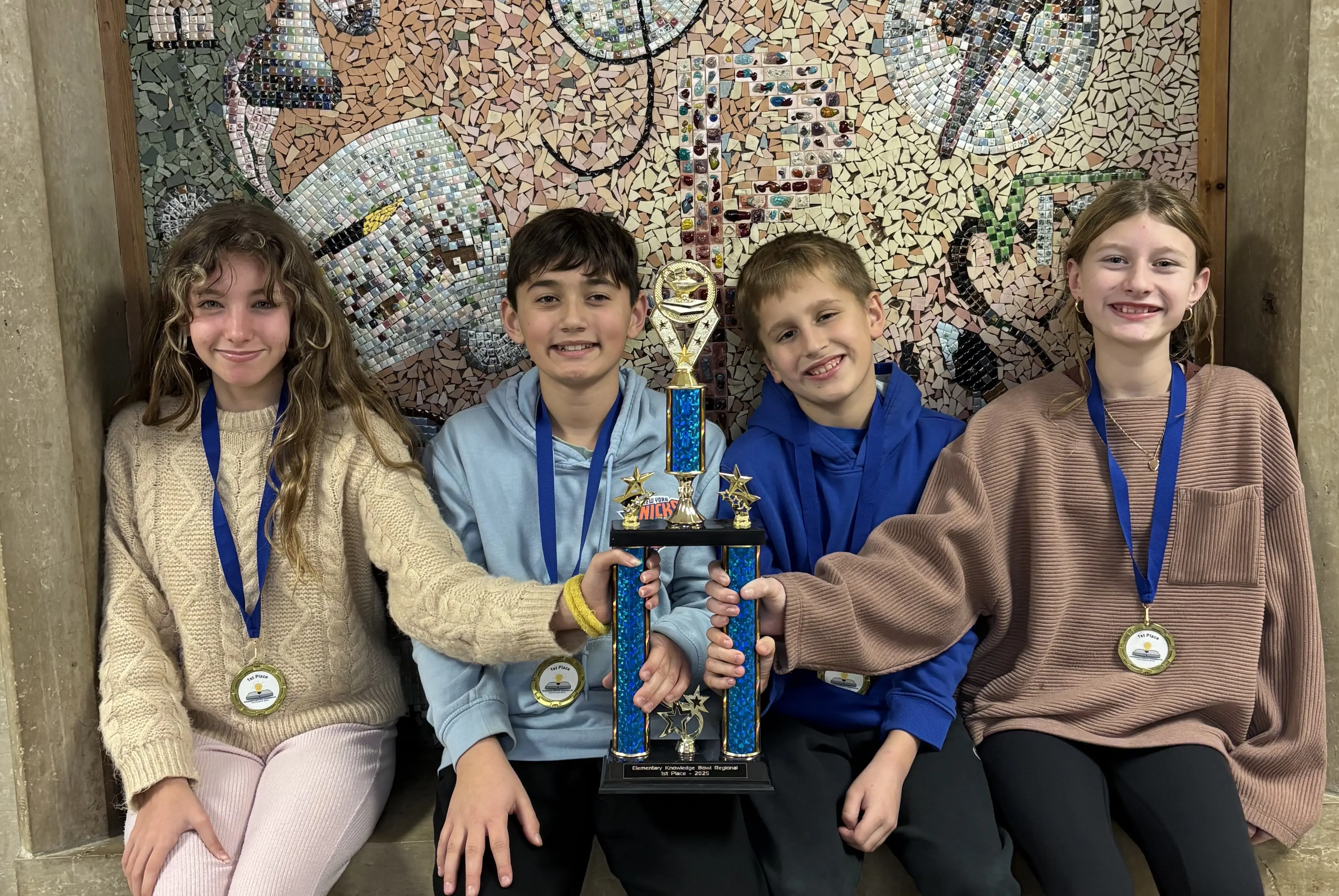 Students holding a trophy and wearing medals
