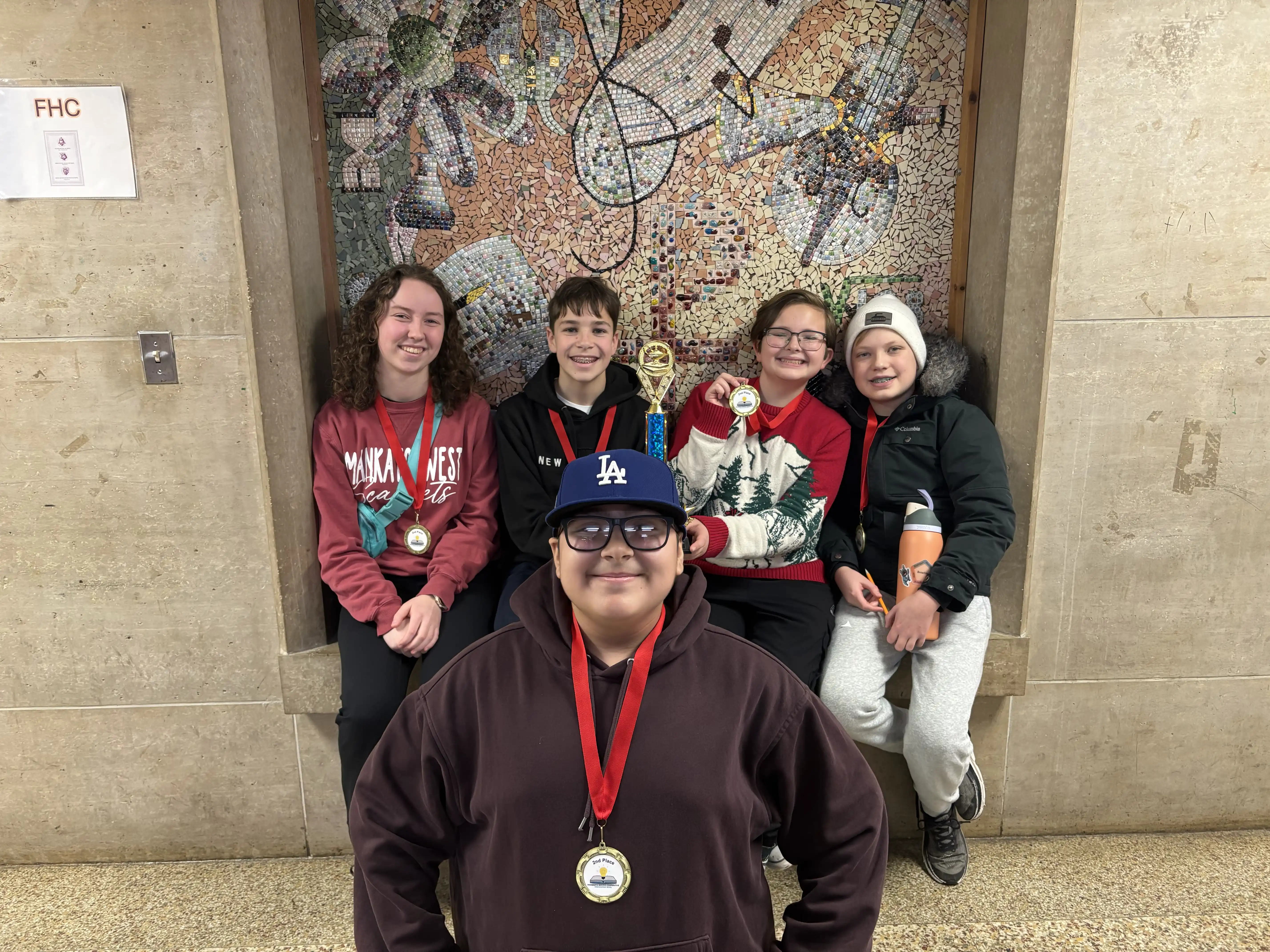 Dakota Meadows Middle School Scarlet students smiling at the camera with their medals