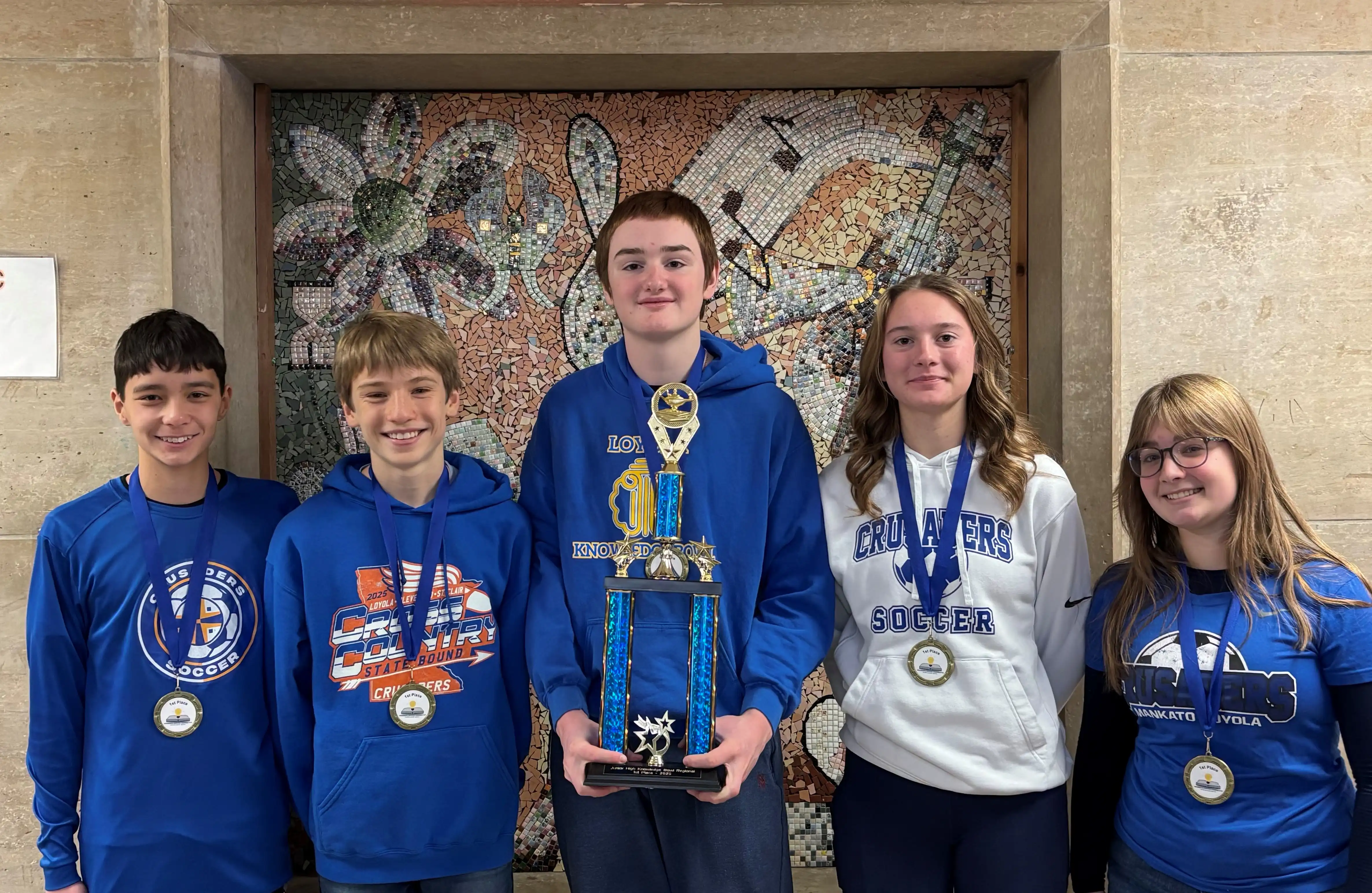 Loyola Uli Uli team members smiling for the camera all holding their trophy and wearing medals