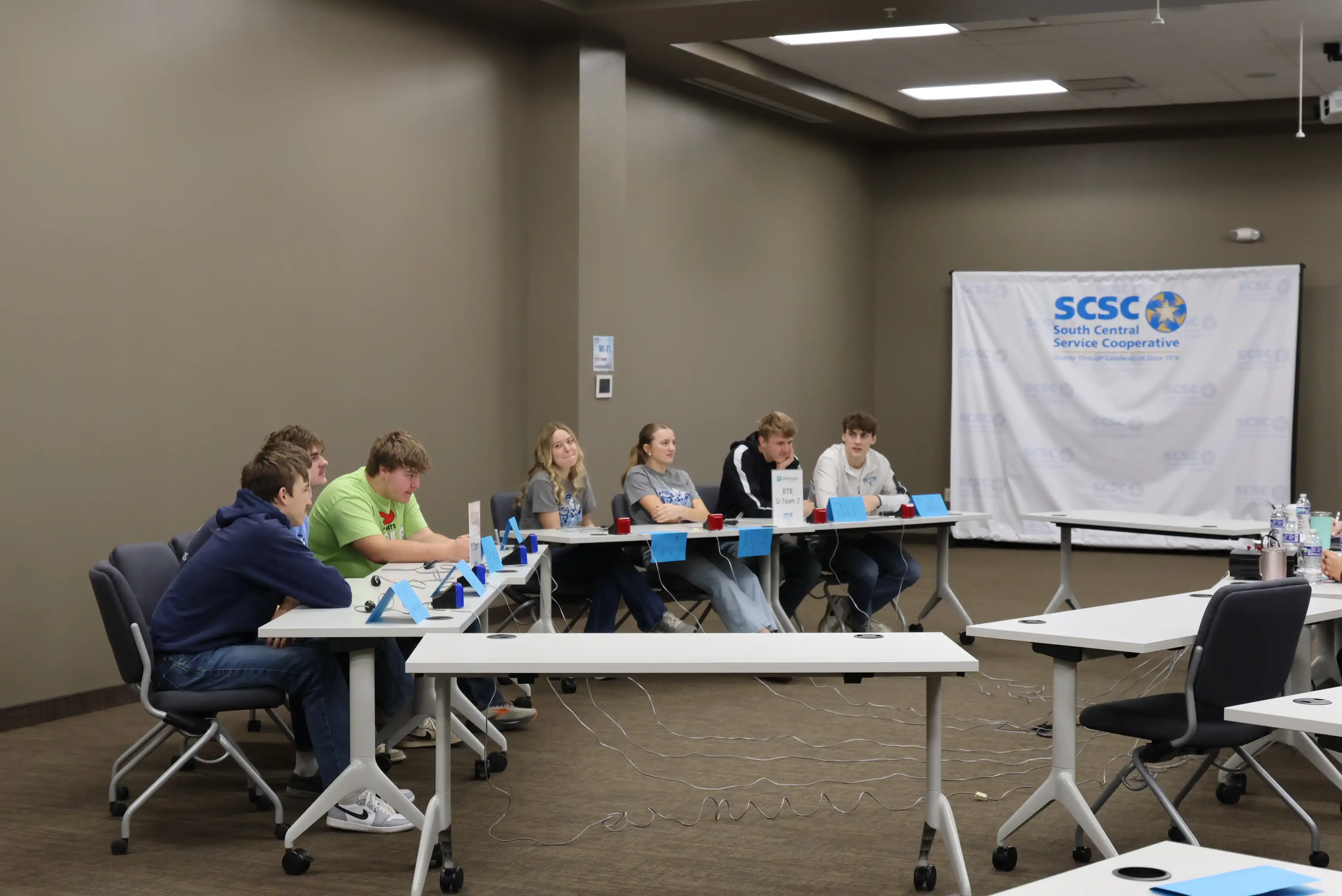 students sitting on one side of an octagon shape of tables