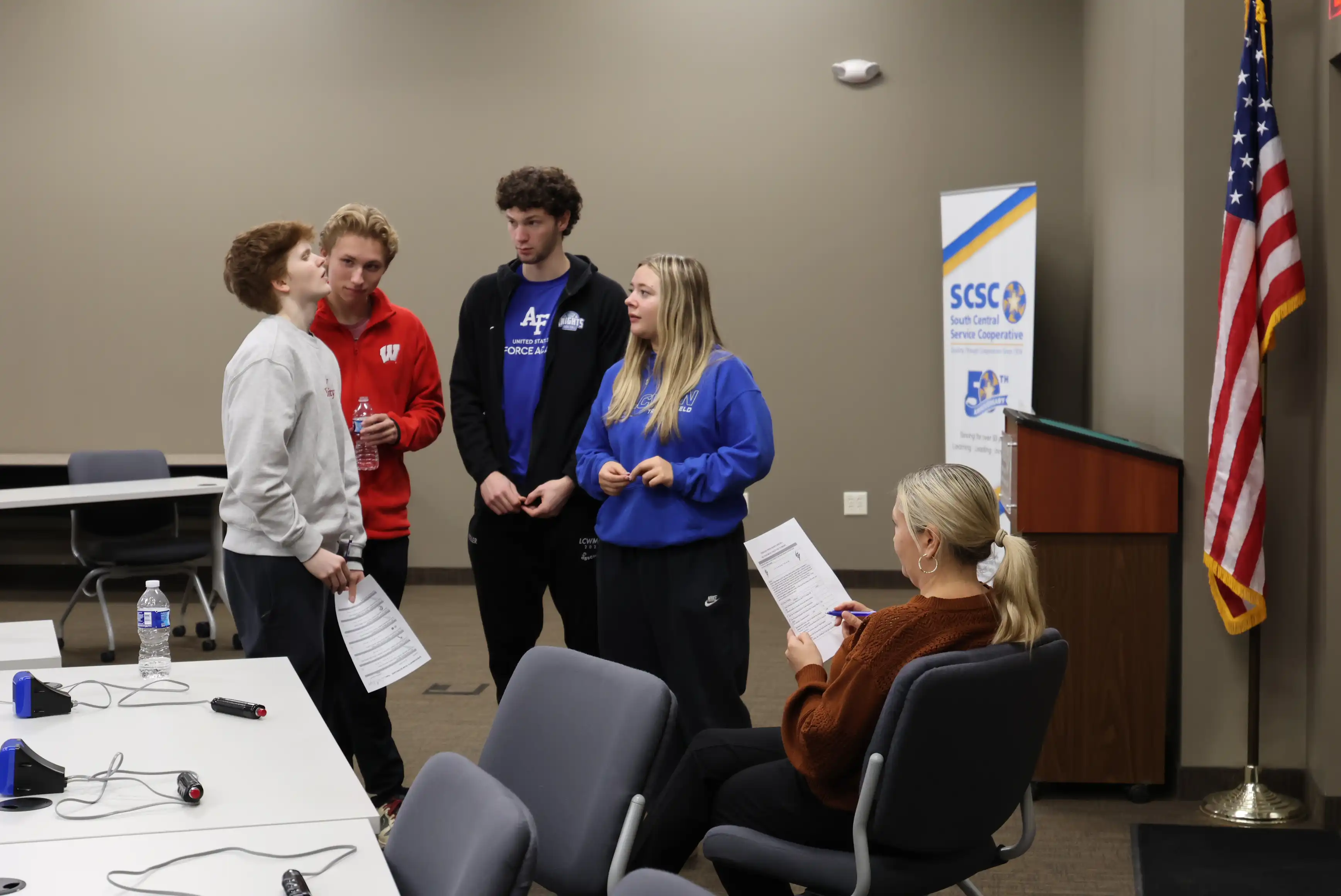 students standing in a group working to answer a question