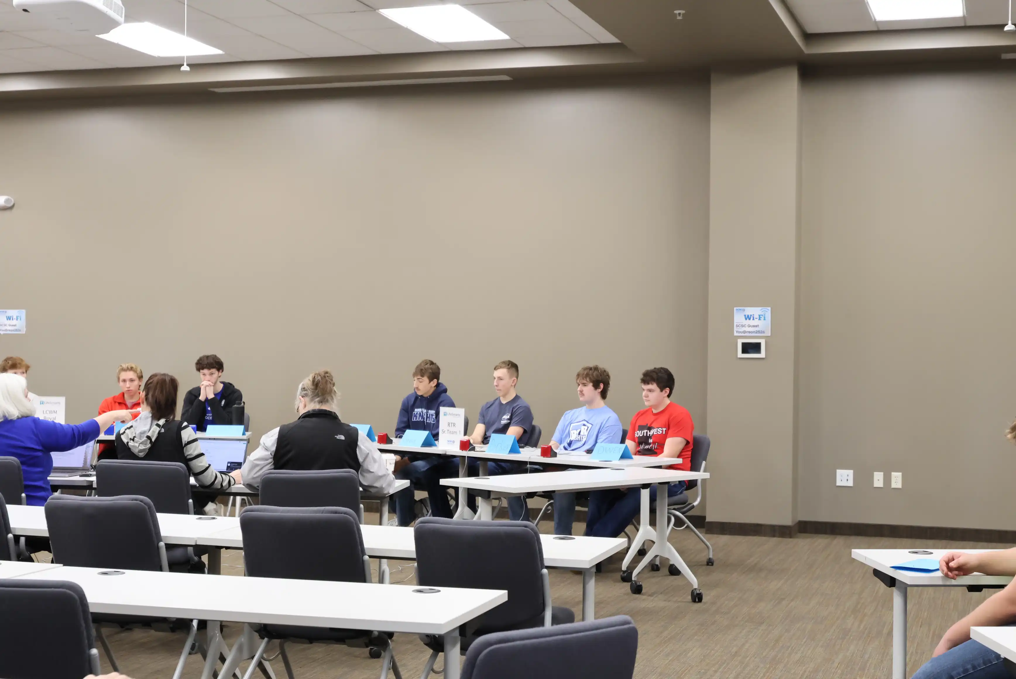 students sitting at a table waiting to answer questions