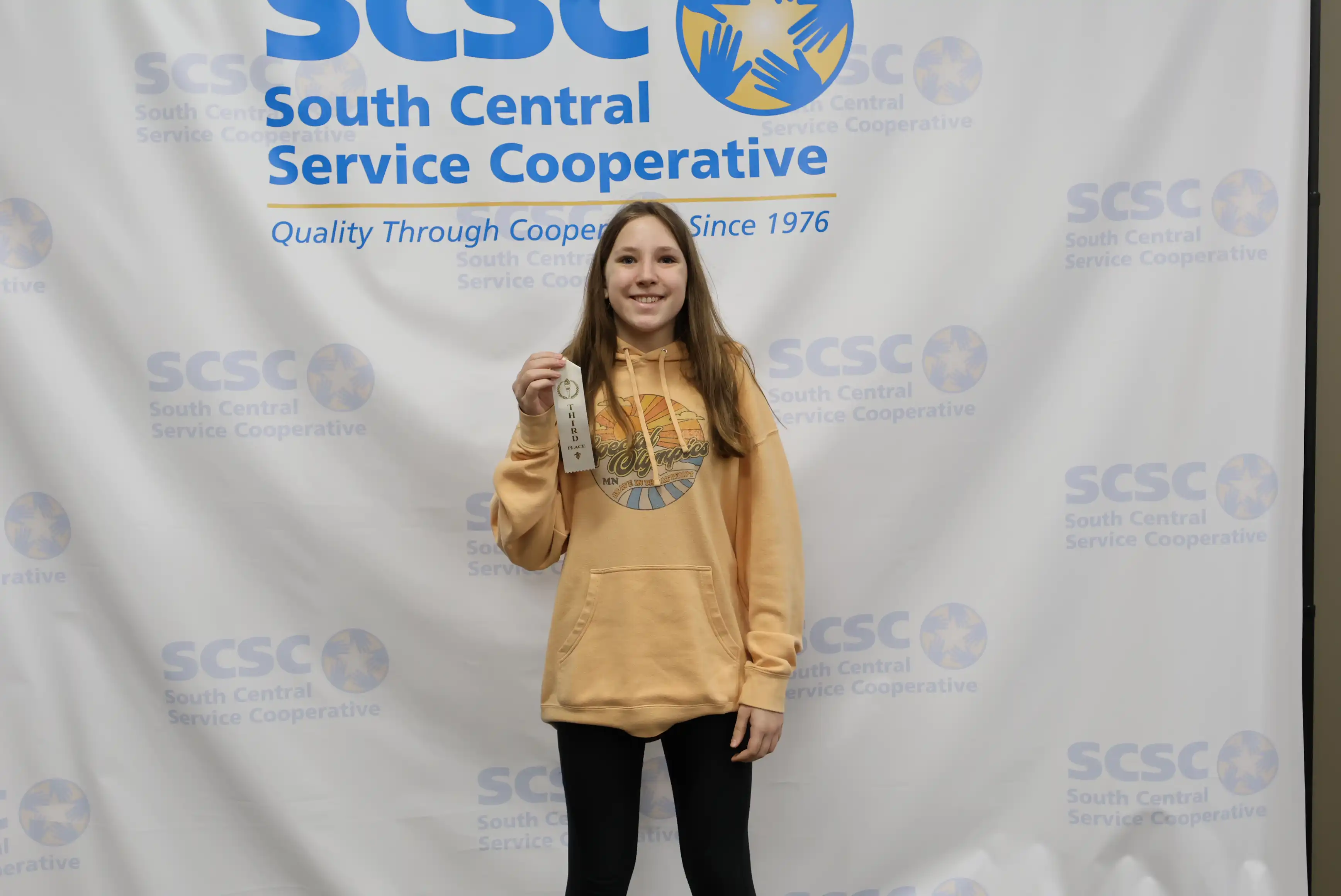 student holding up ribbon
