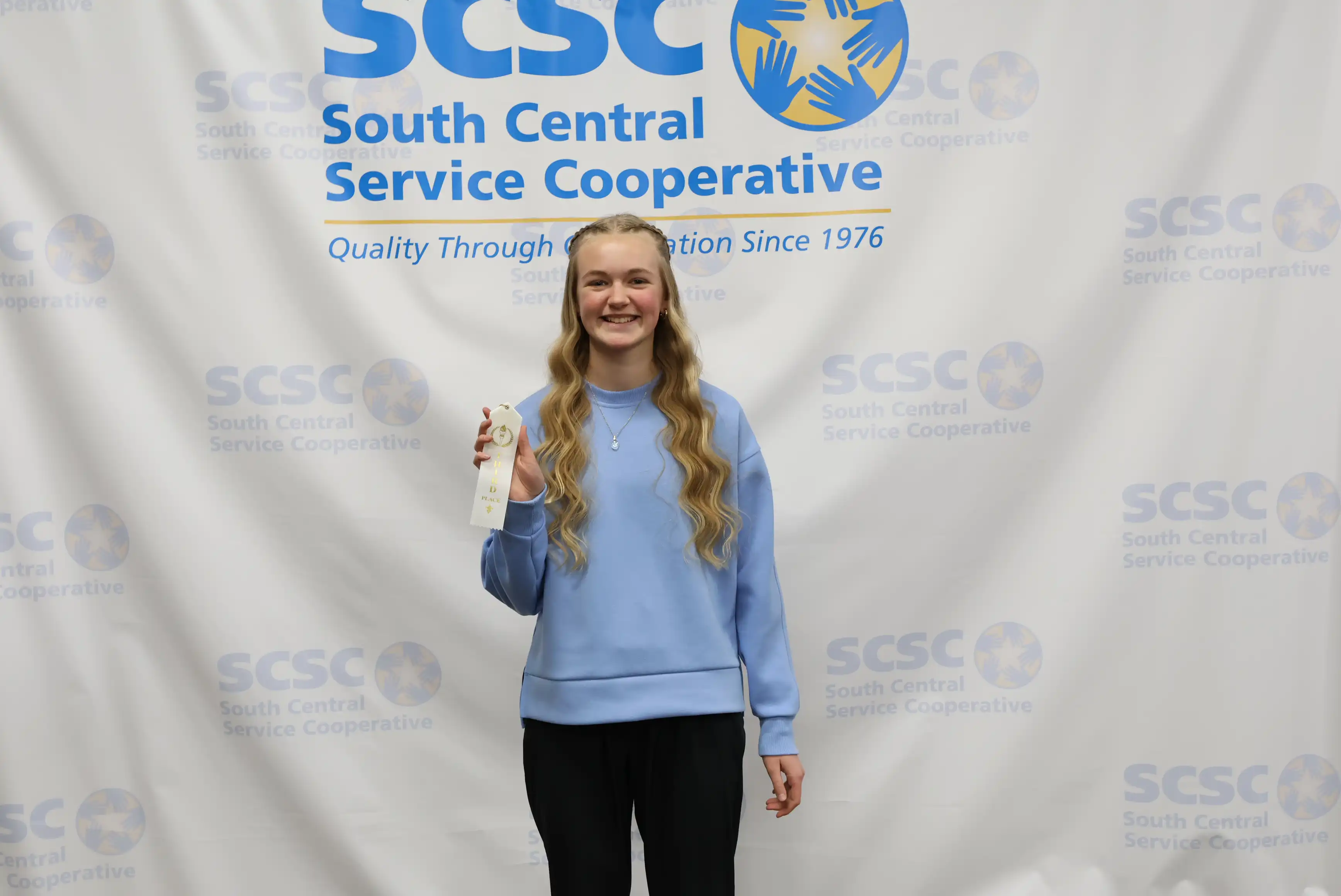 student holding up ribbon