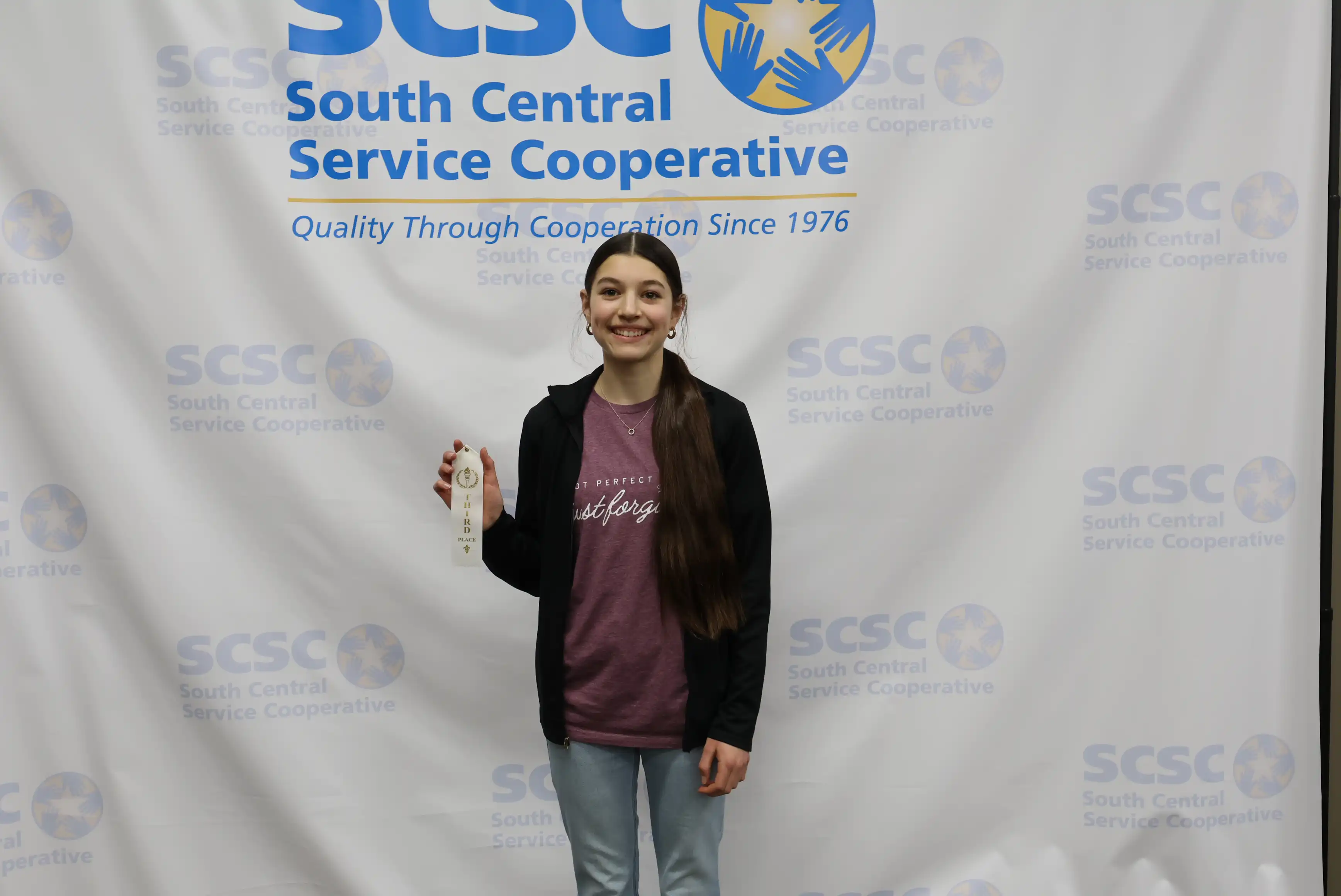 student holding up ribbon