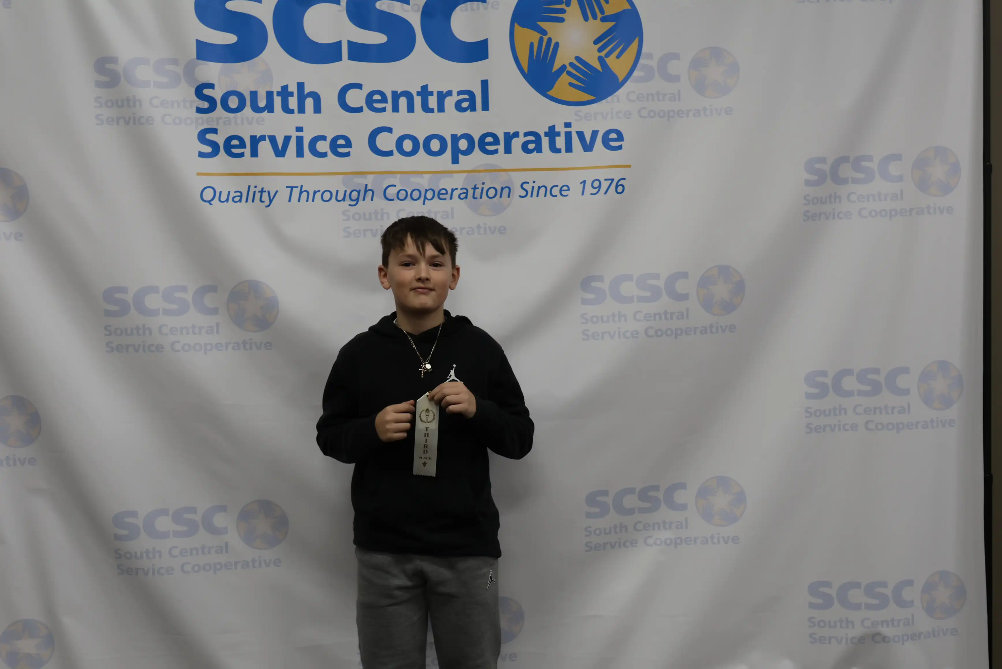 student holding up ribbon