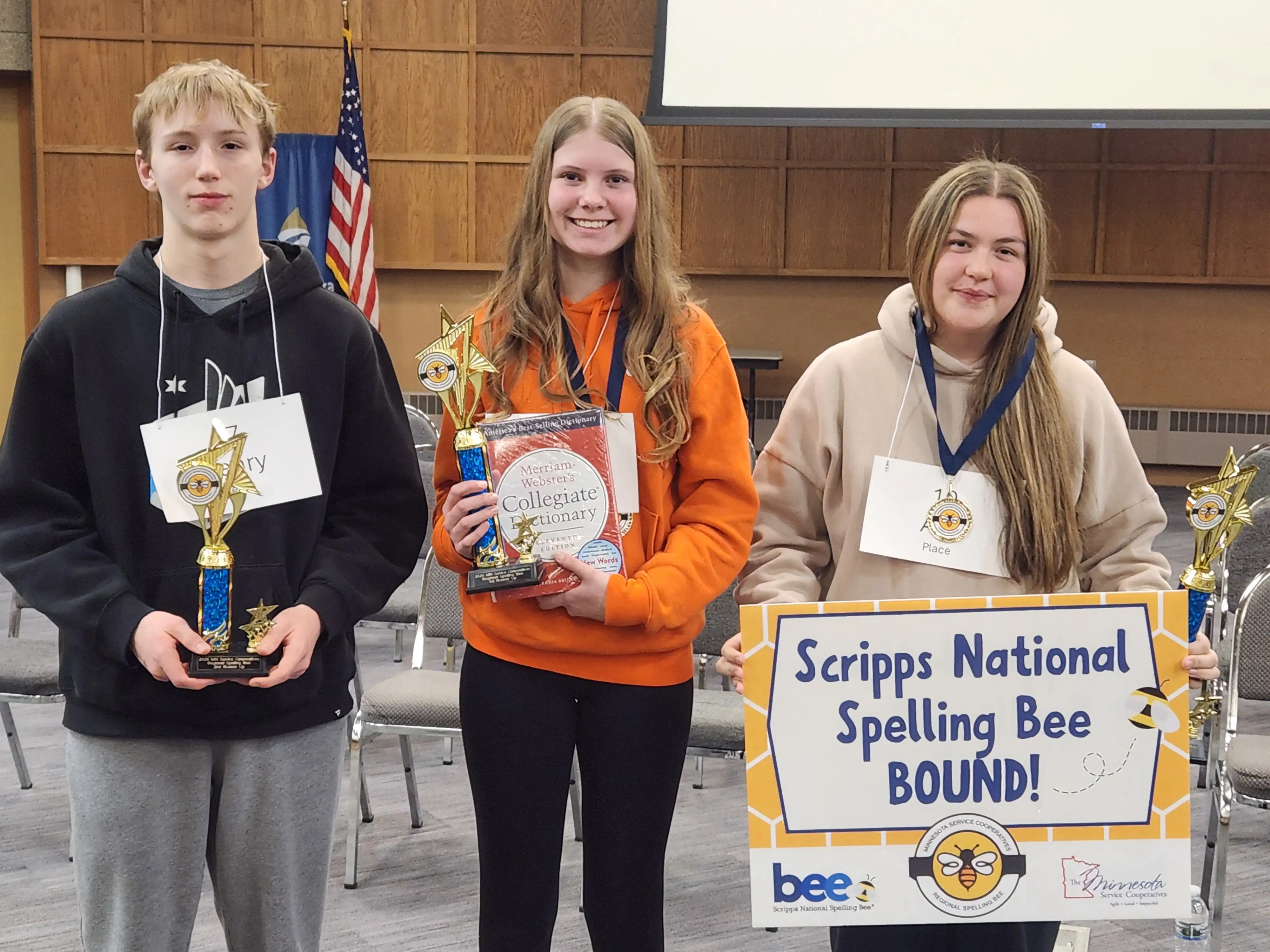 3 students standing together holding awards