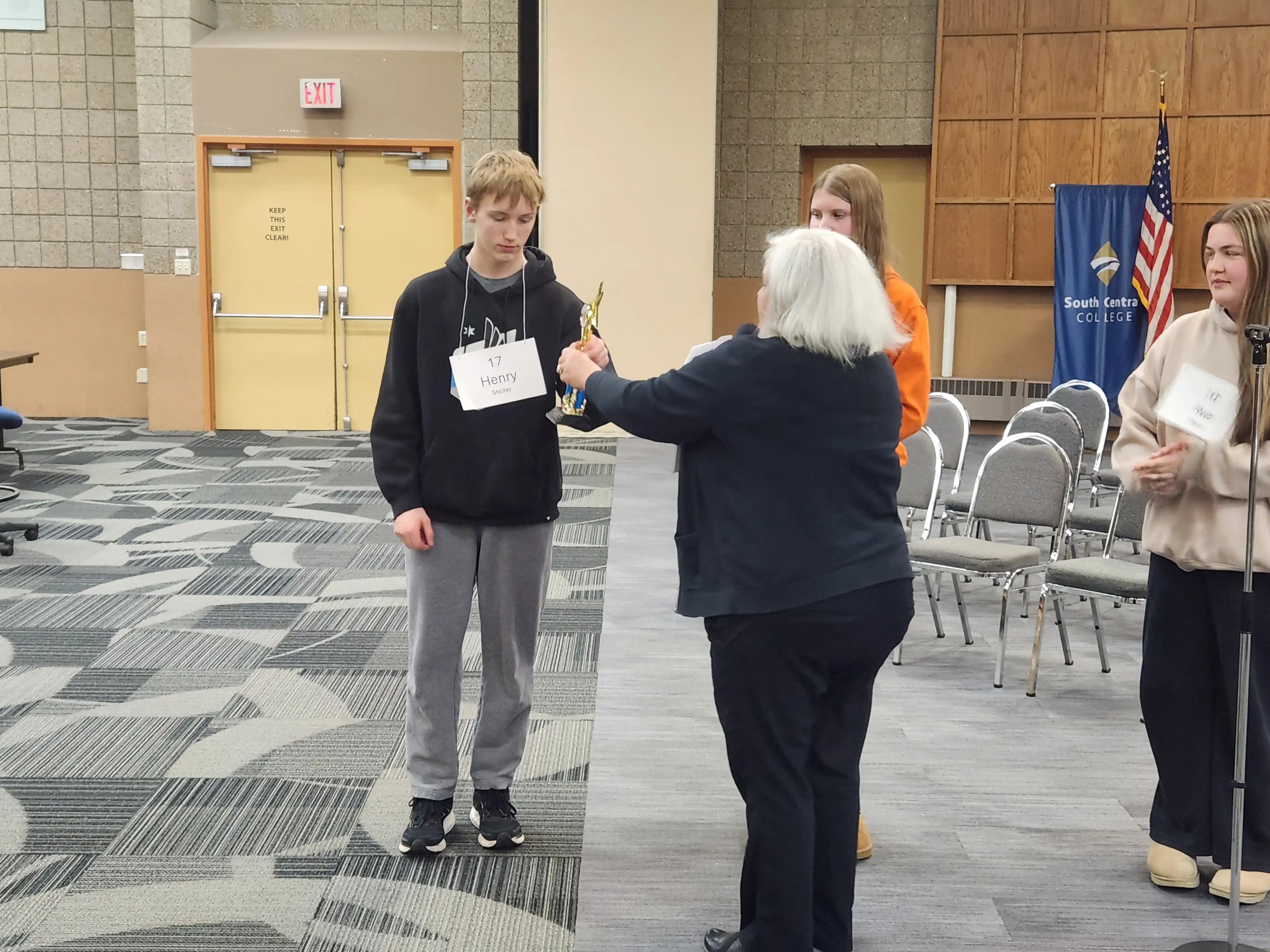 Student receiving trophy award for spelling bee