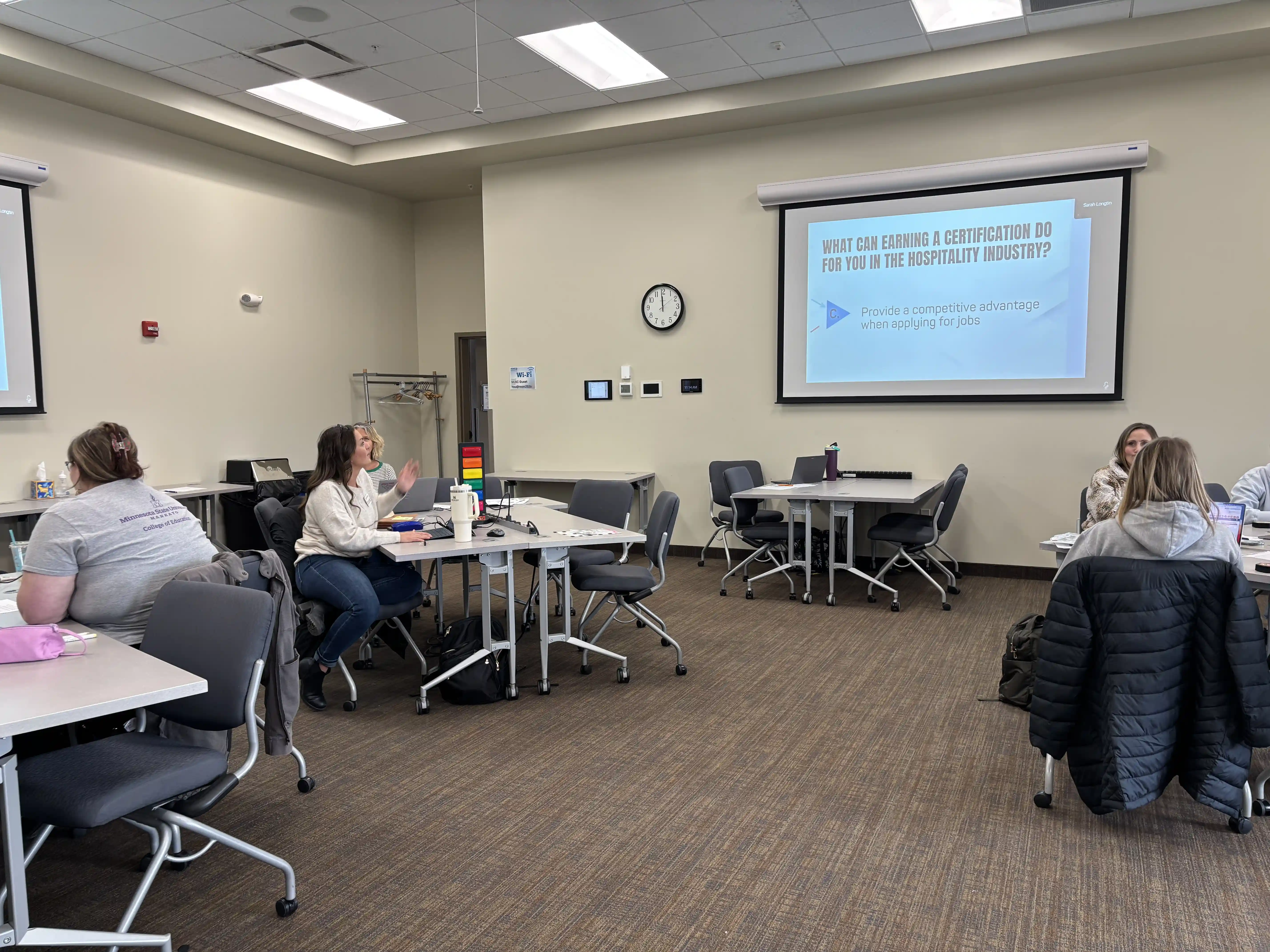 Family and Consumer Educators in a Community of Practice Meeting sharing resources and looking at a screen on the wall with information