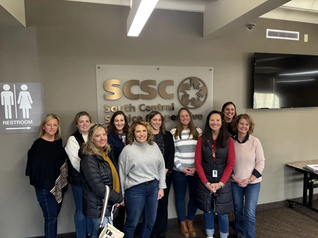 A group of teachers standing together and smiling for a group photo