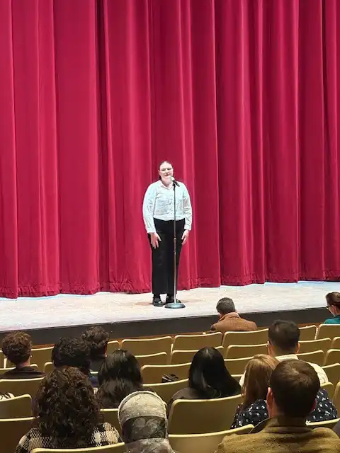 student on stage reciting their poem