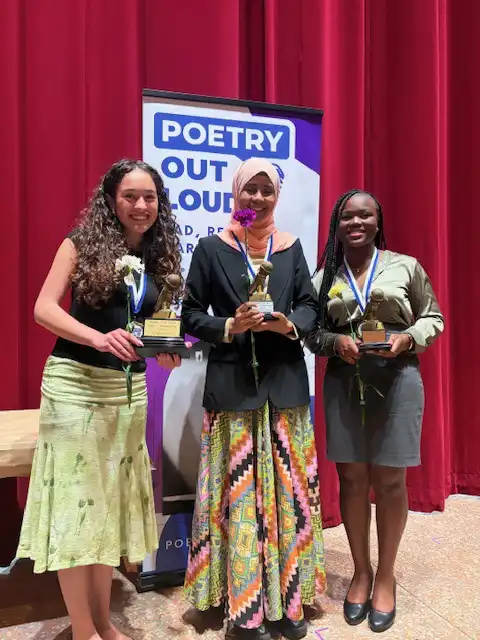Top 3 winners standing on stage with their awards and smiling