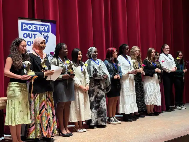 Group of students standing on stage with their awards