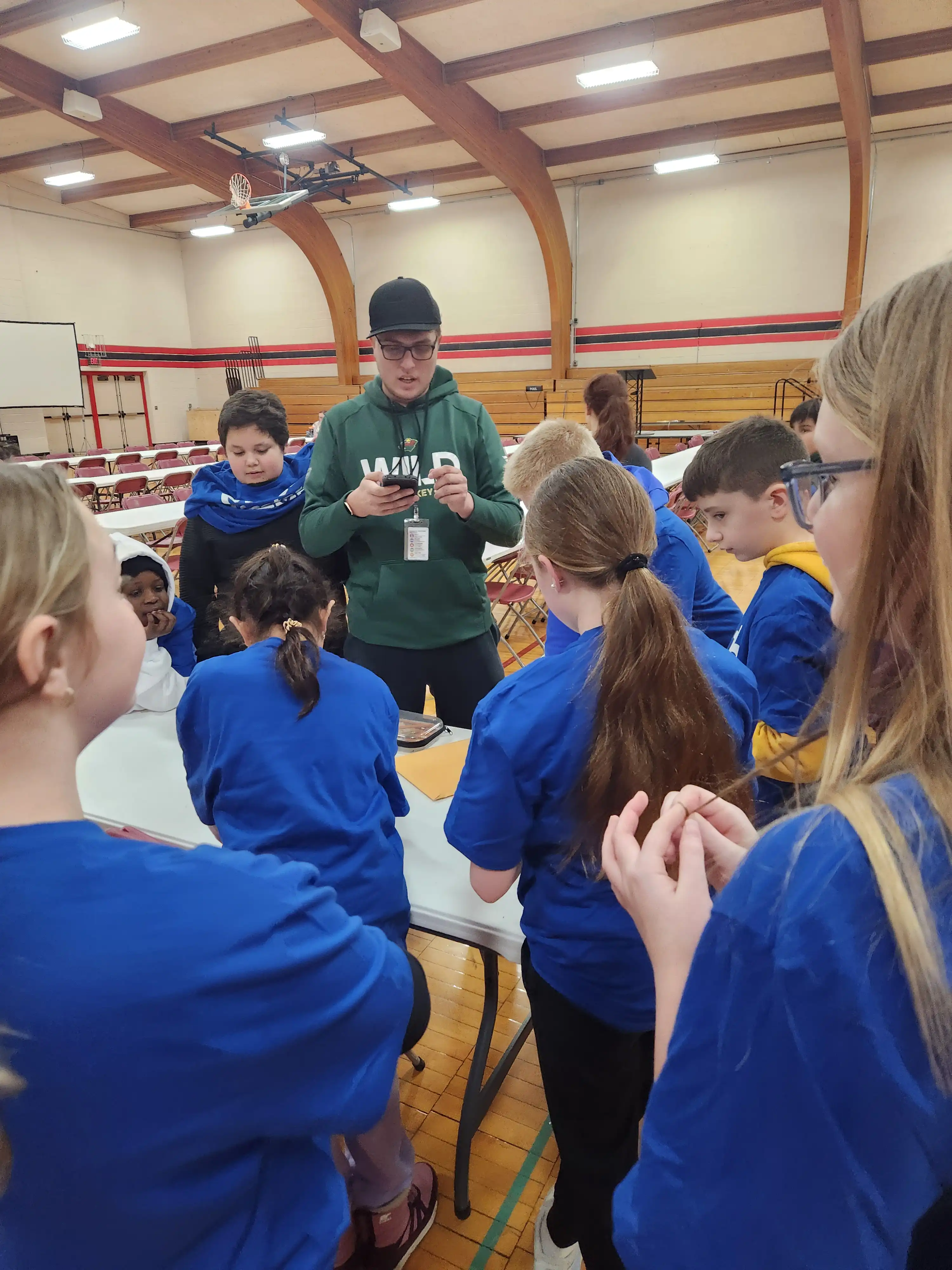 Students standing in a circle around an adult getting ready to work on math problems