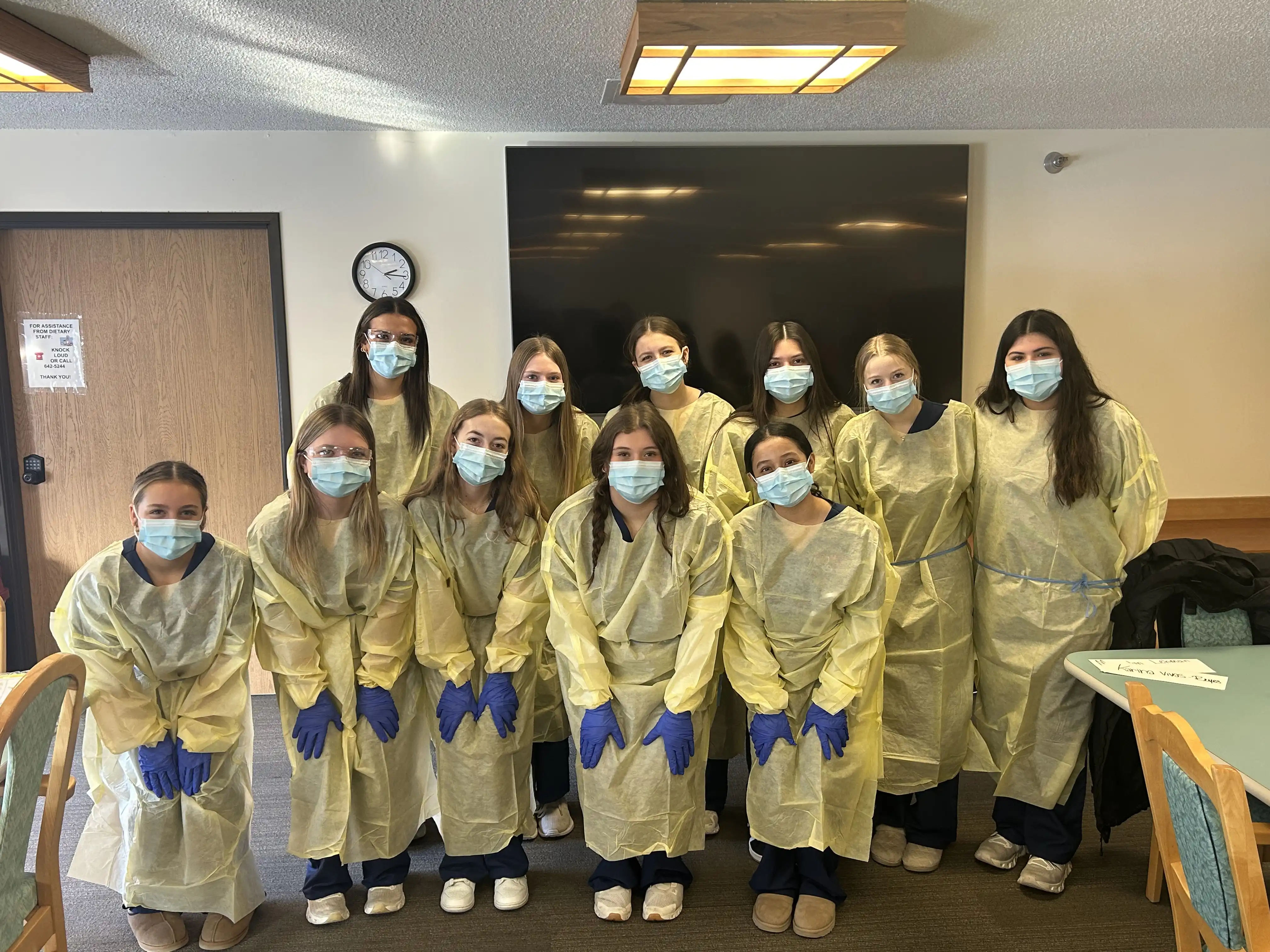 group of High STEP students posing in a group with masks clothing protectors and gloves on.