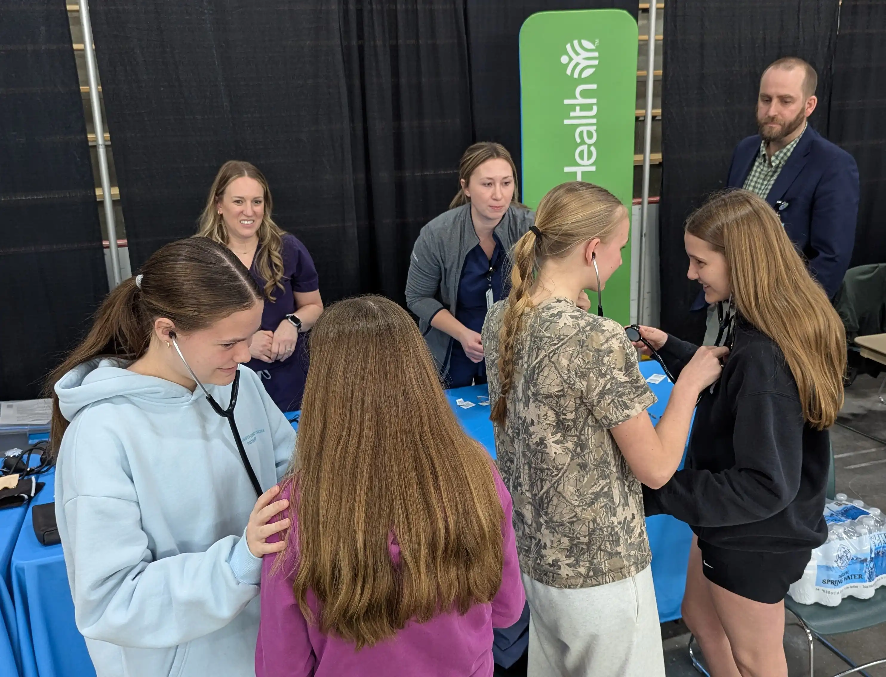 Students standing around a table booth.