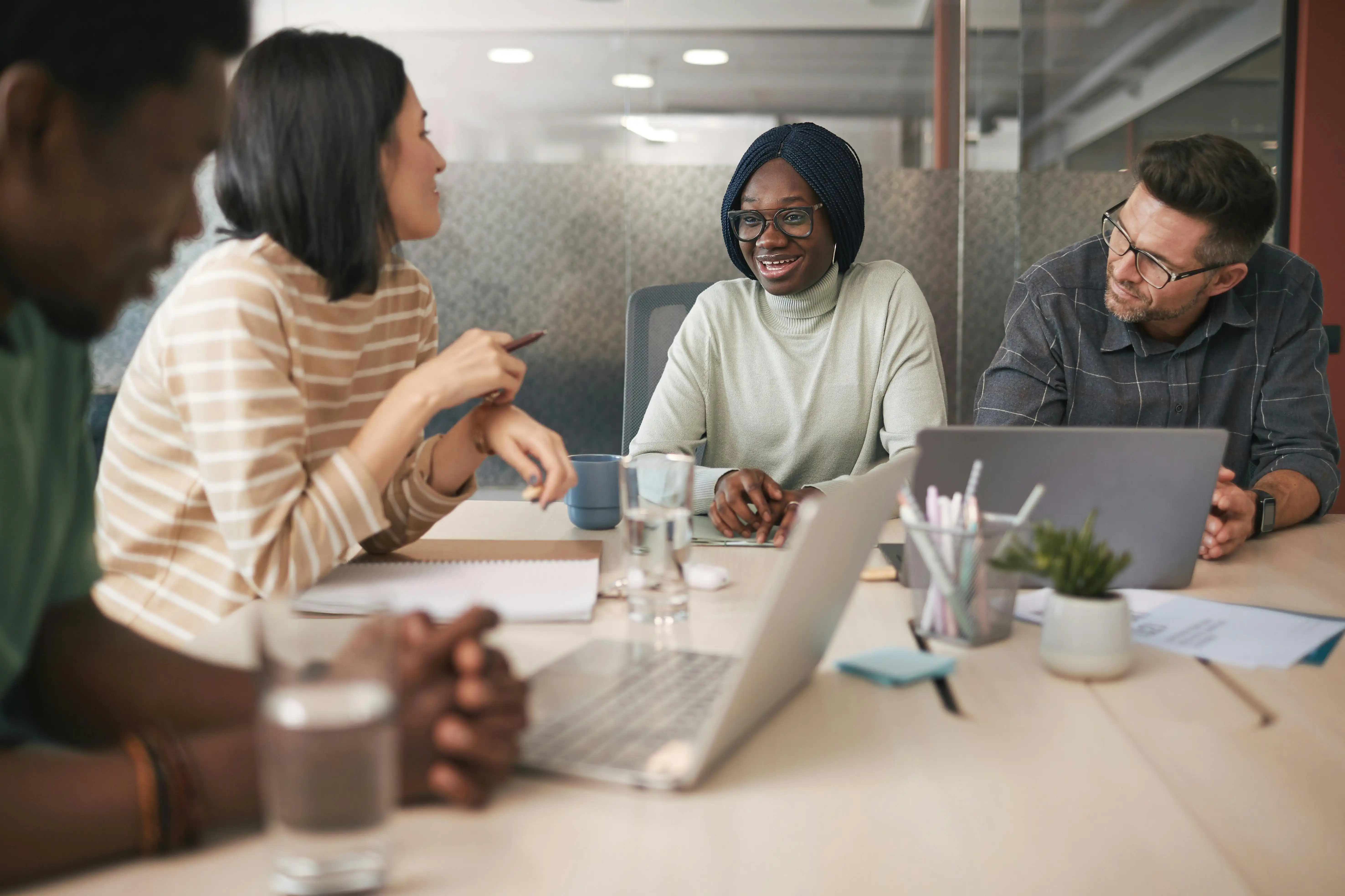 A group of adults sitting around a table have a meeting and discussing the solution.