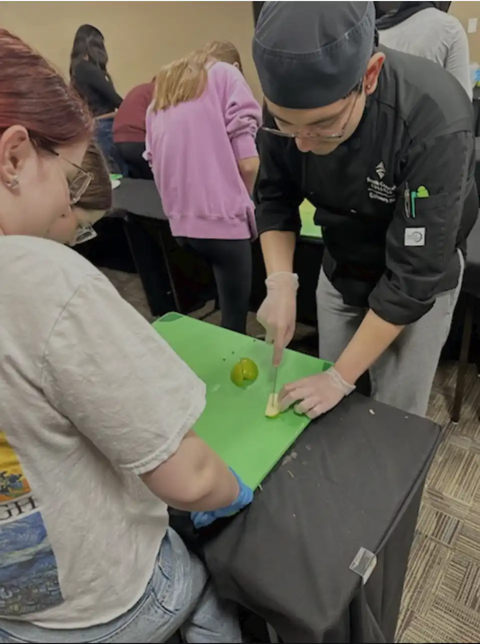 Students cutting fruit on a cutting board