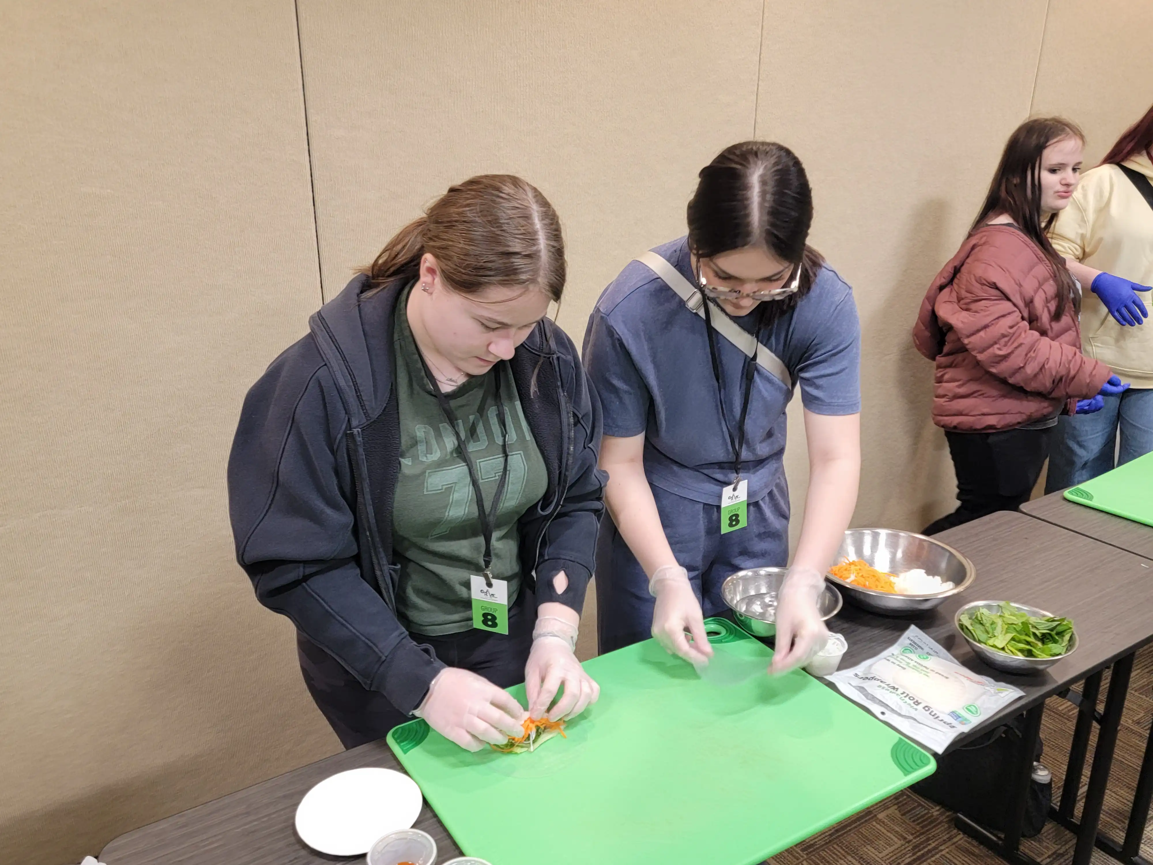 Students at a tables turning their fruit cuttings into fruit art.