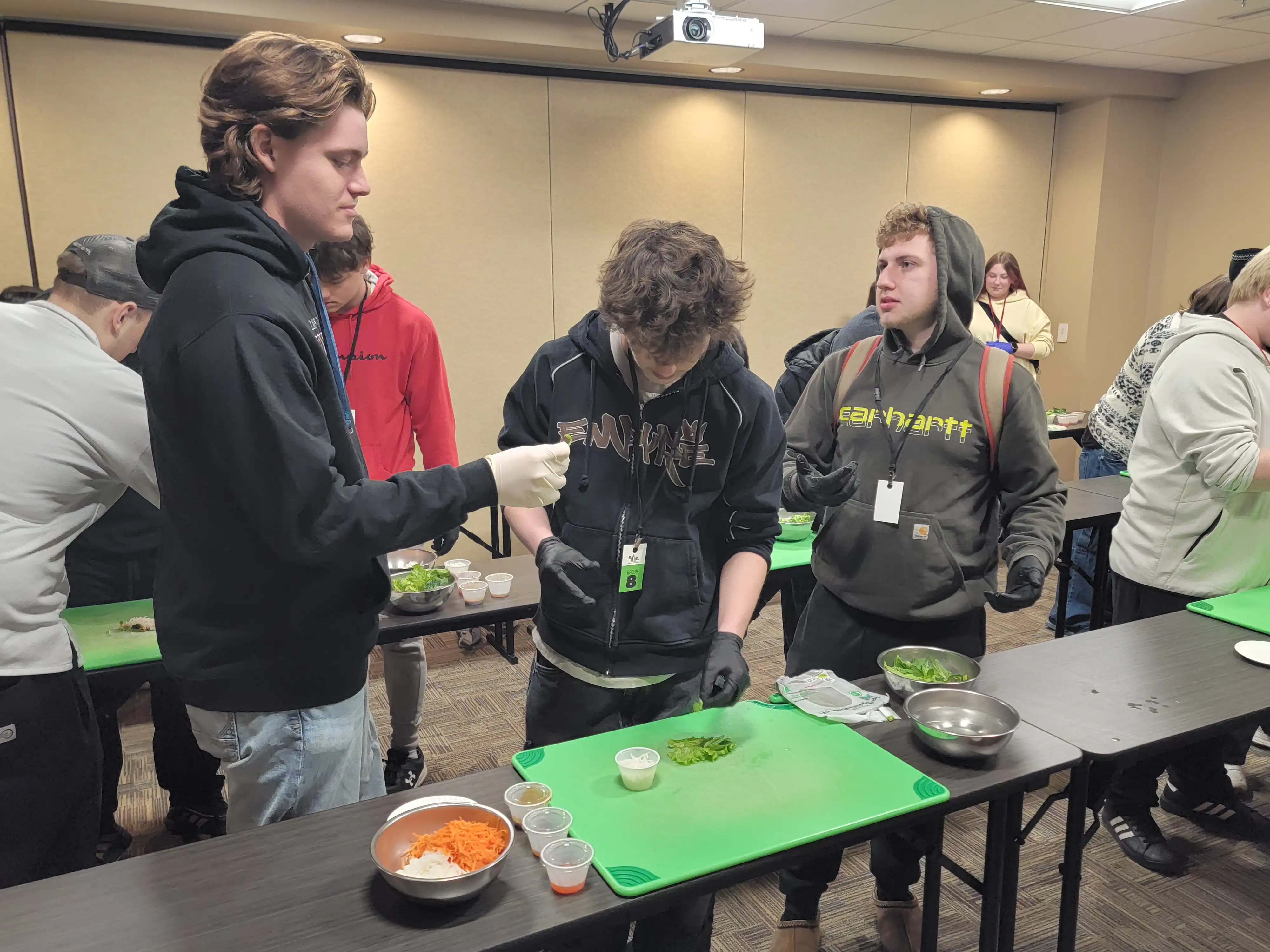 3 students working together to create their fruit art.