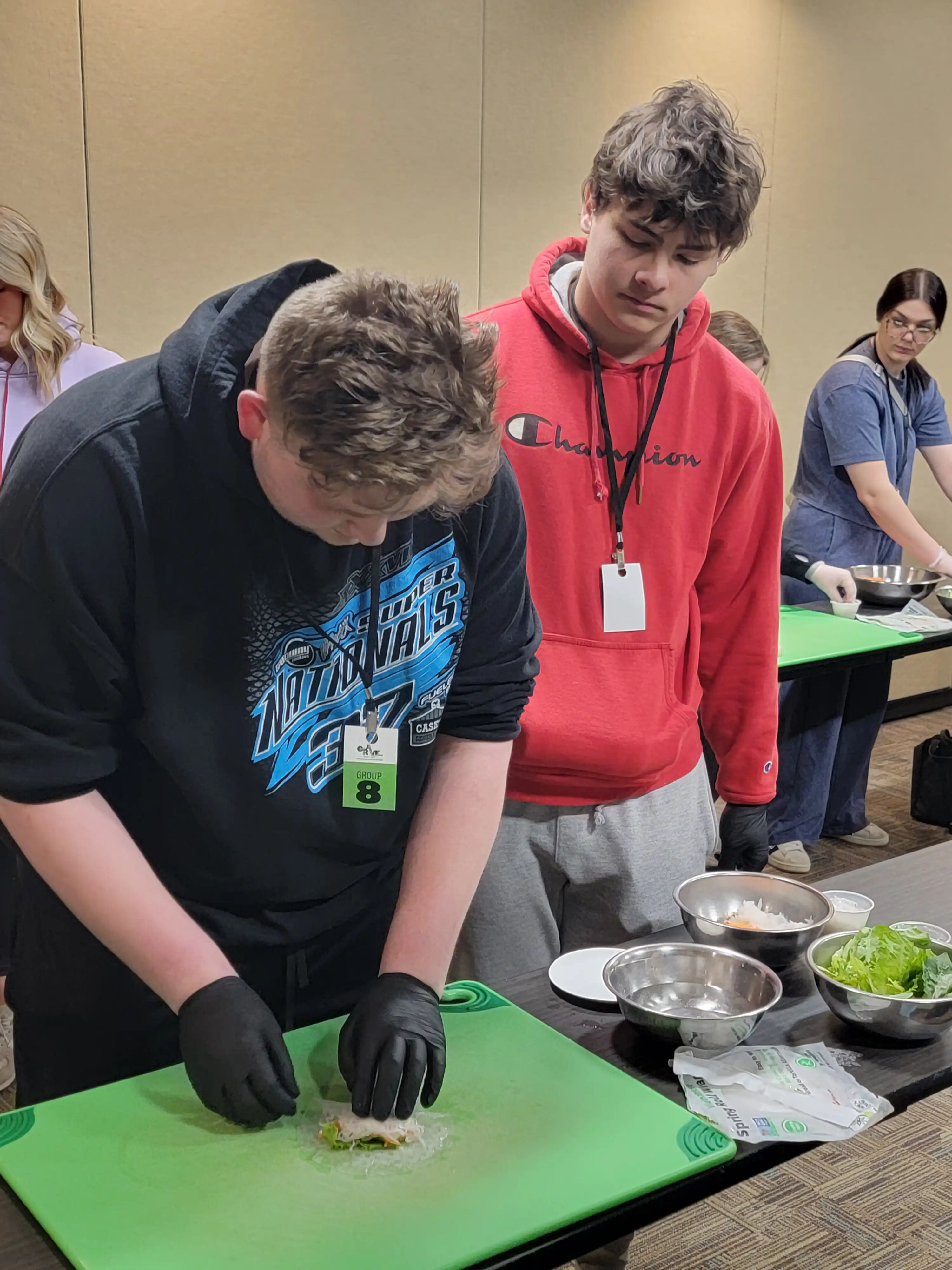 2 students working together to create their cut up fruit into art.