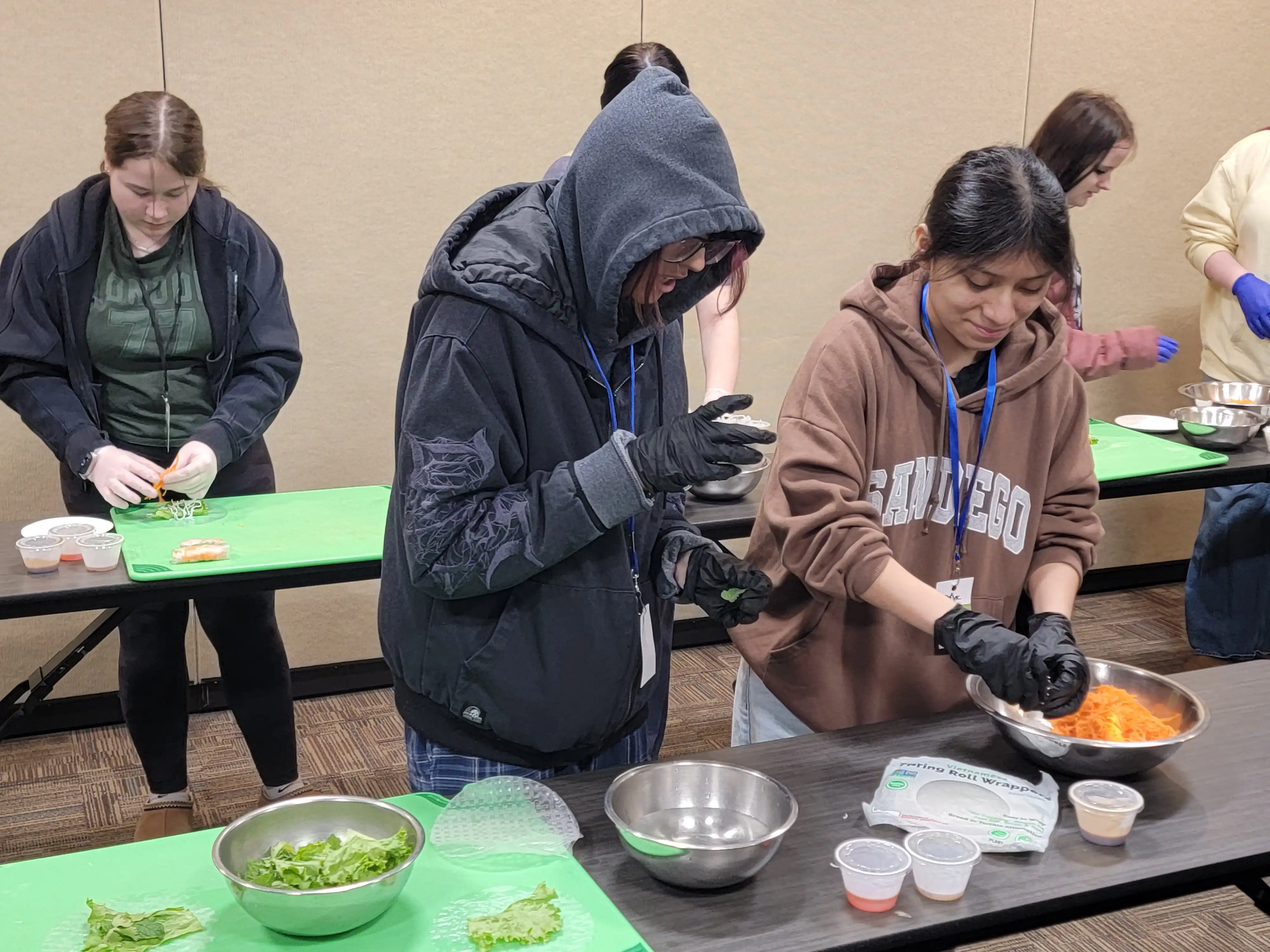 2 students mixing food in a bowl.