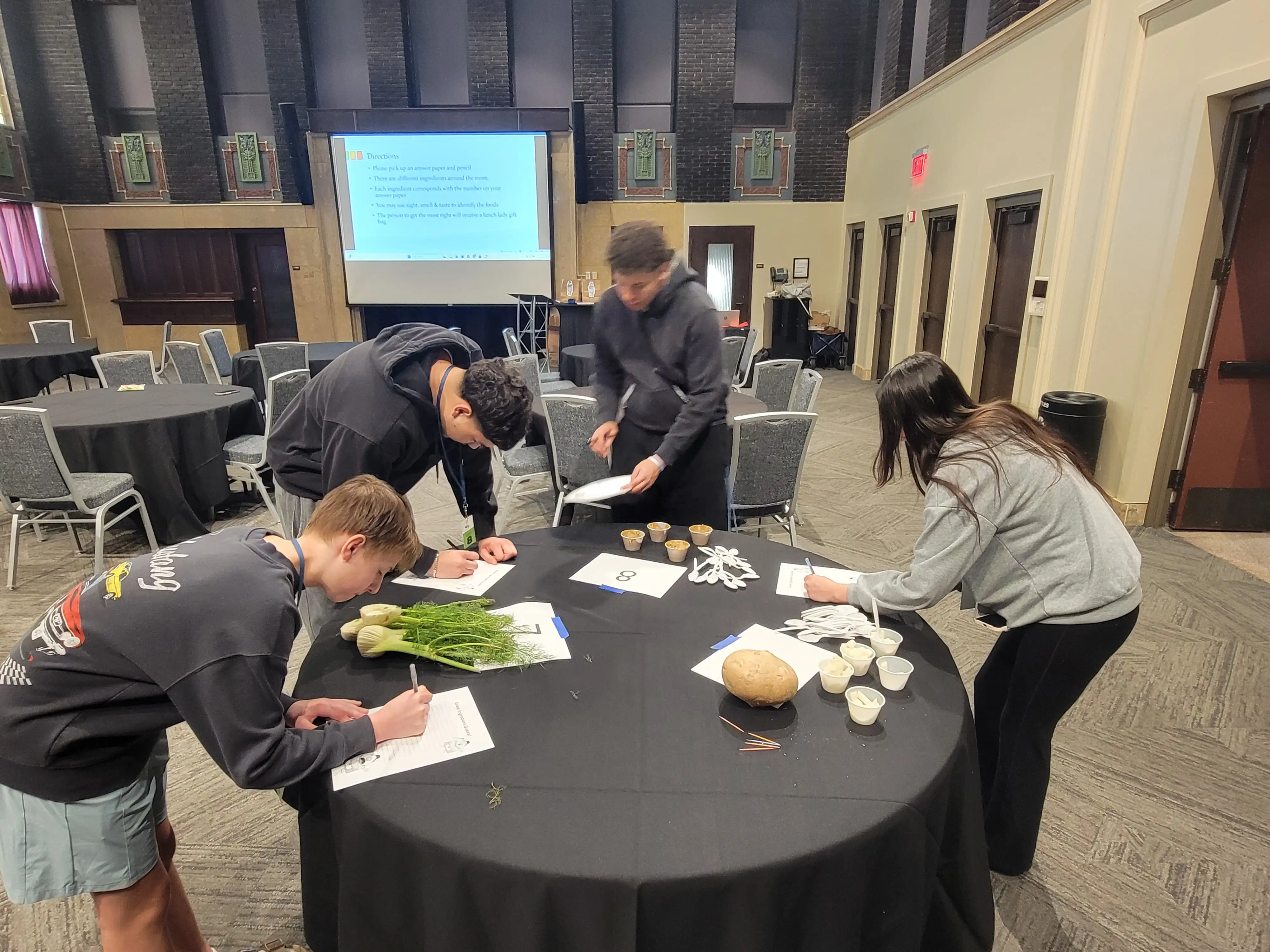 students working around a circle table and working on papers to fill out