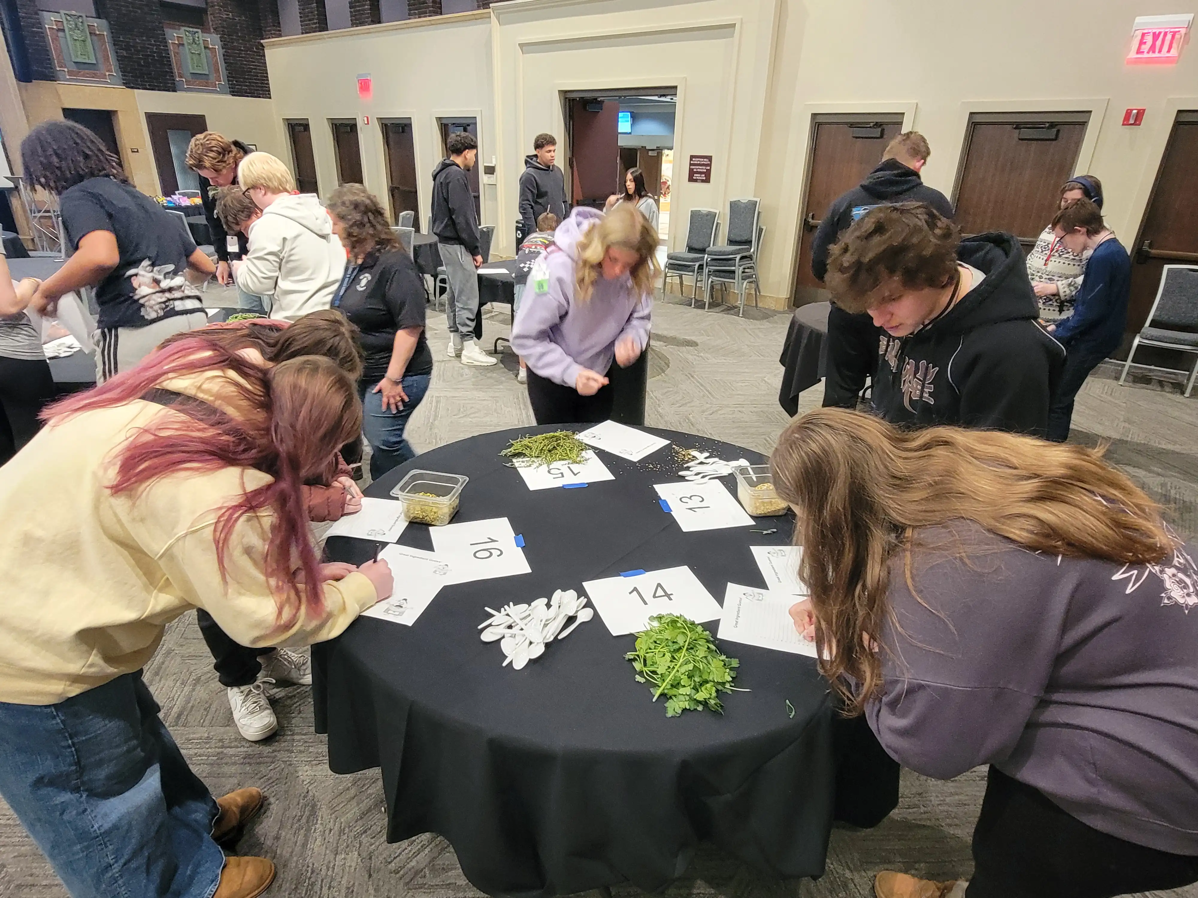 students working around a circle table on their worksheets.