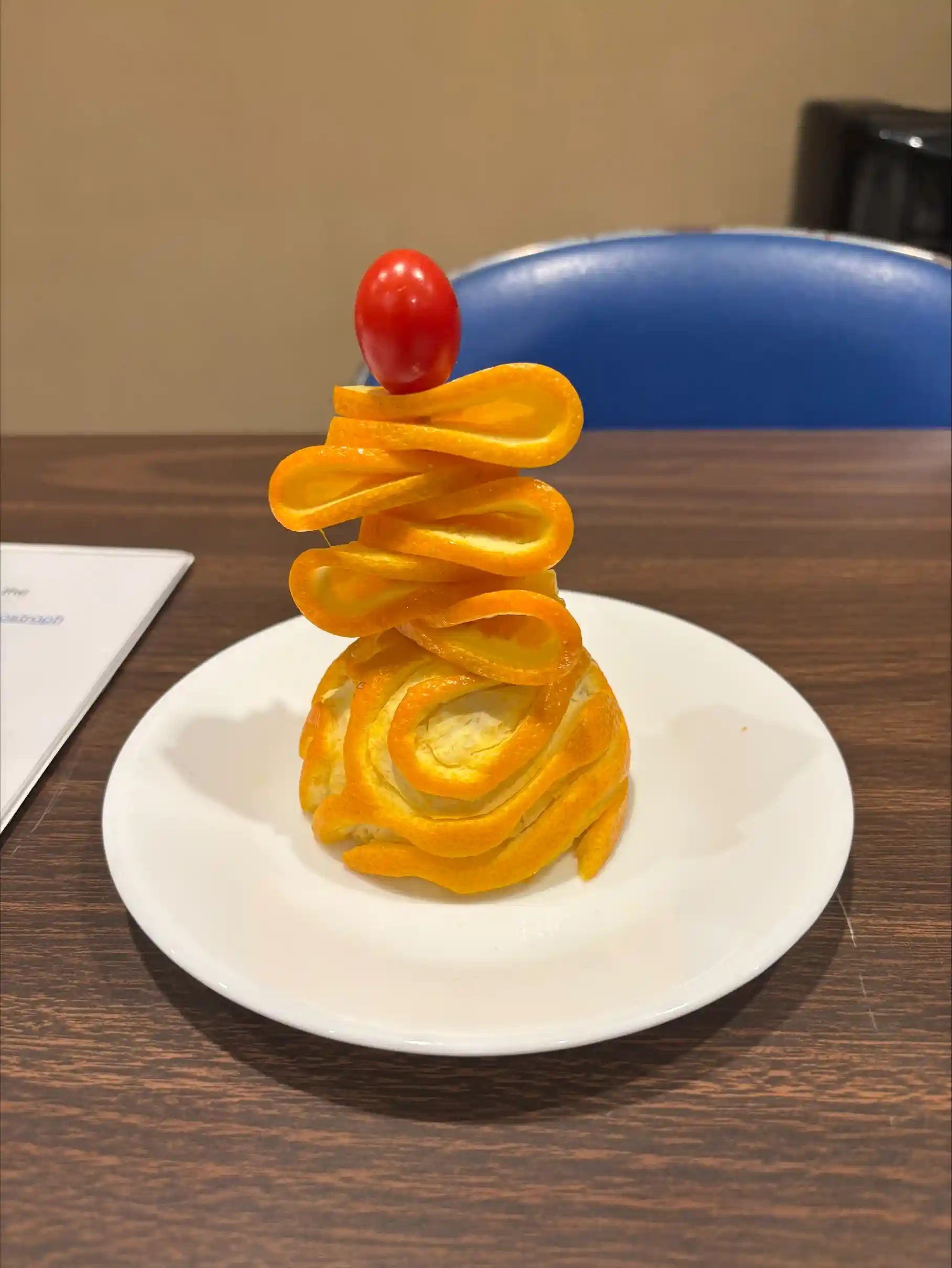 An orange cut and sculpted into a shape.