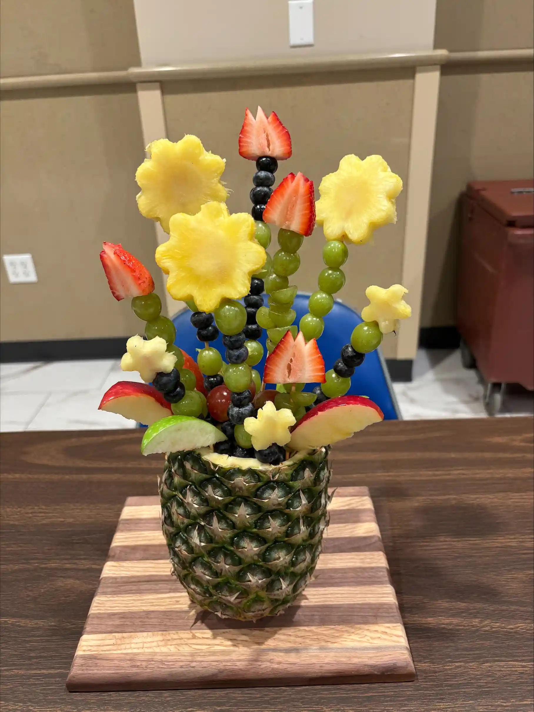 Fruit cut into shapes of flowers in a pineapple vase