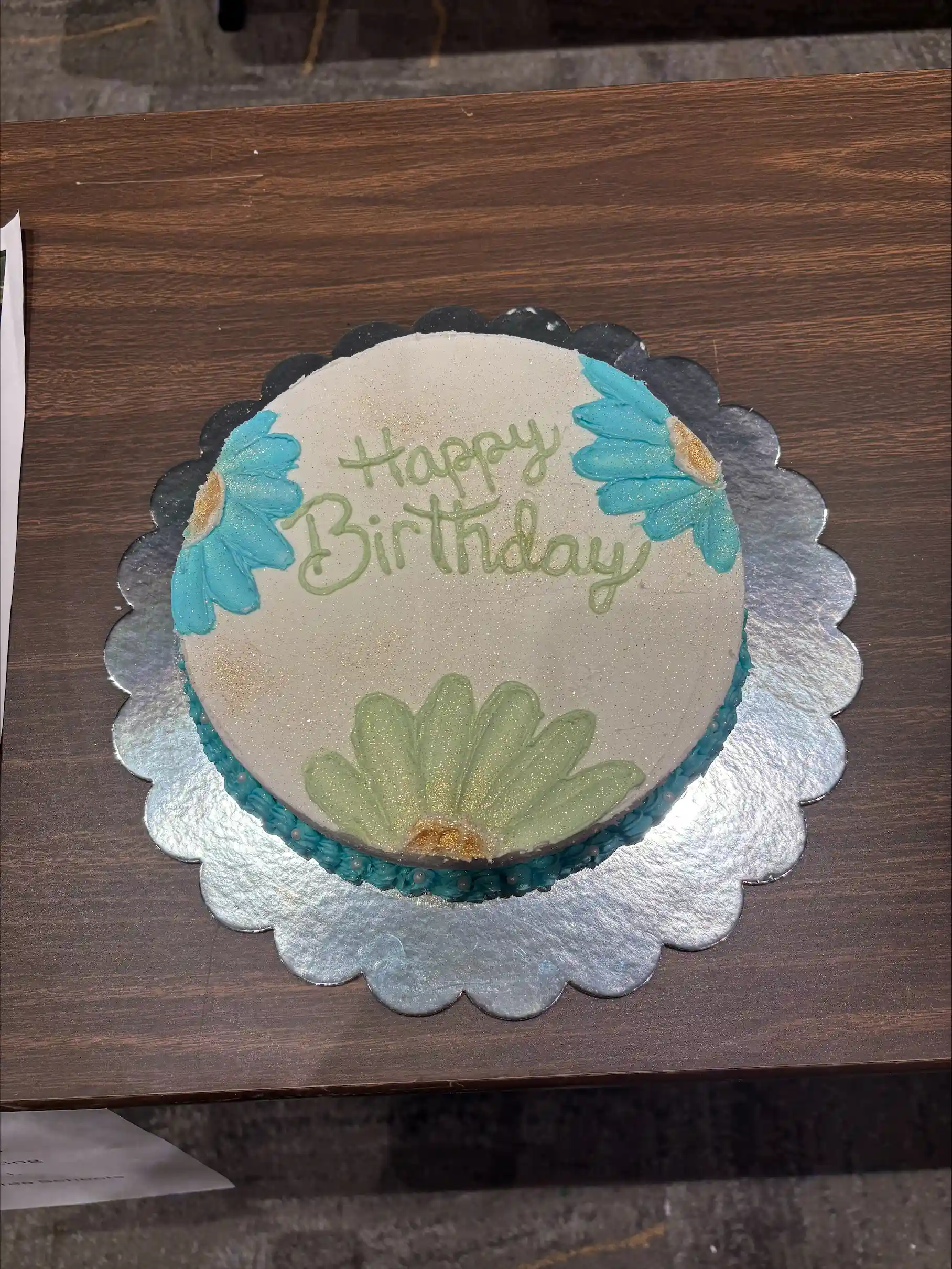 Cake with flowers decorated on top with the words "Happy Birthday"