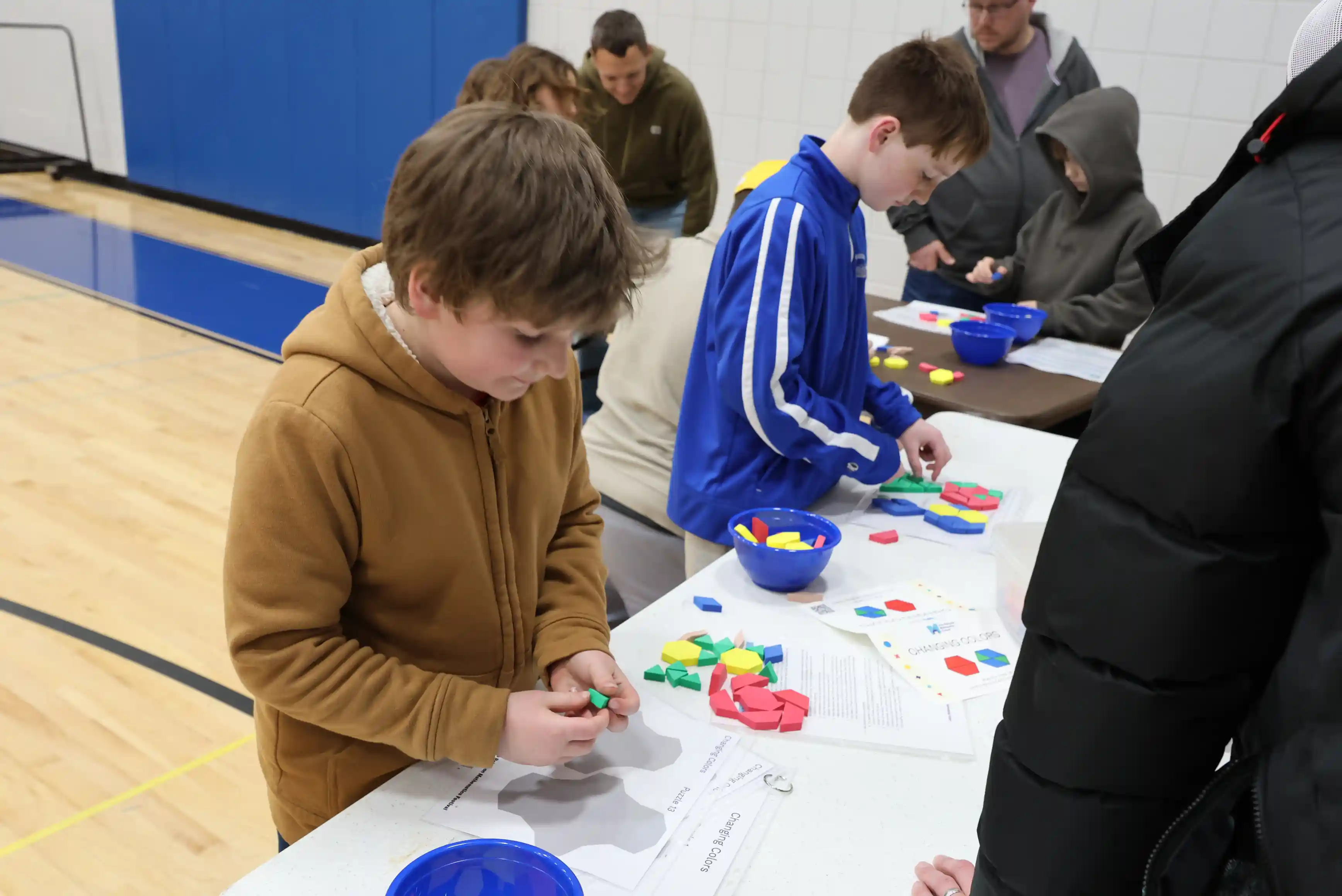 students working at a table on shape math problems