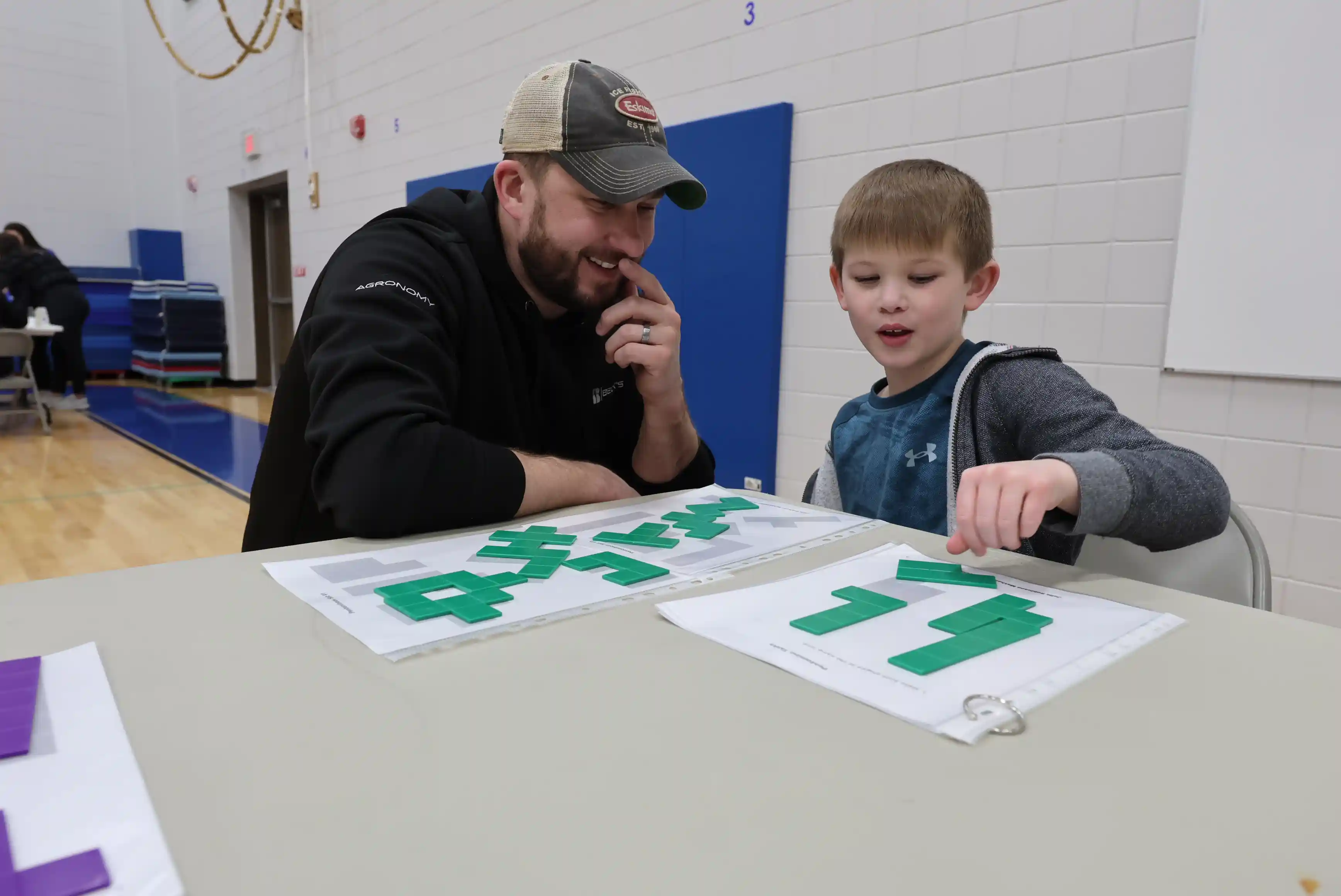 Student and parent working together on shapes at a table