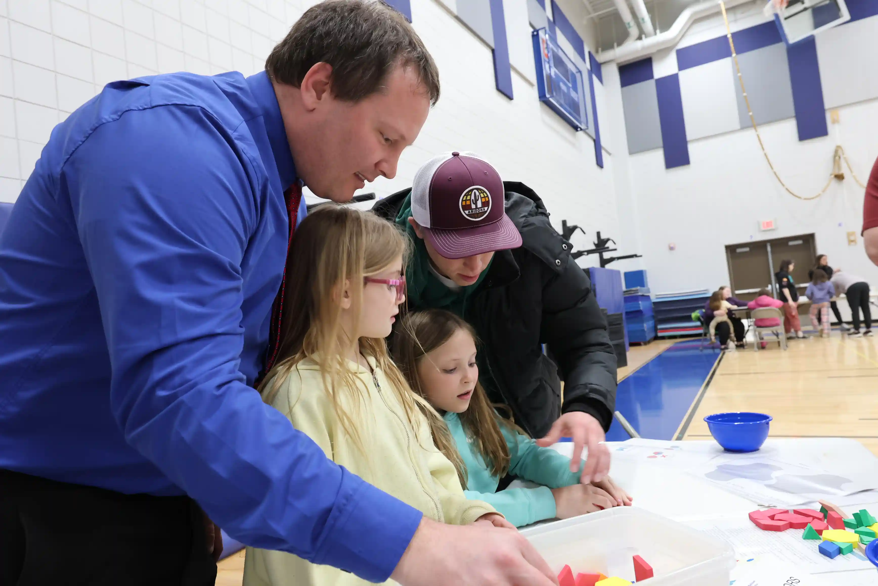 2 parents and 2 students working on math problems with shapes