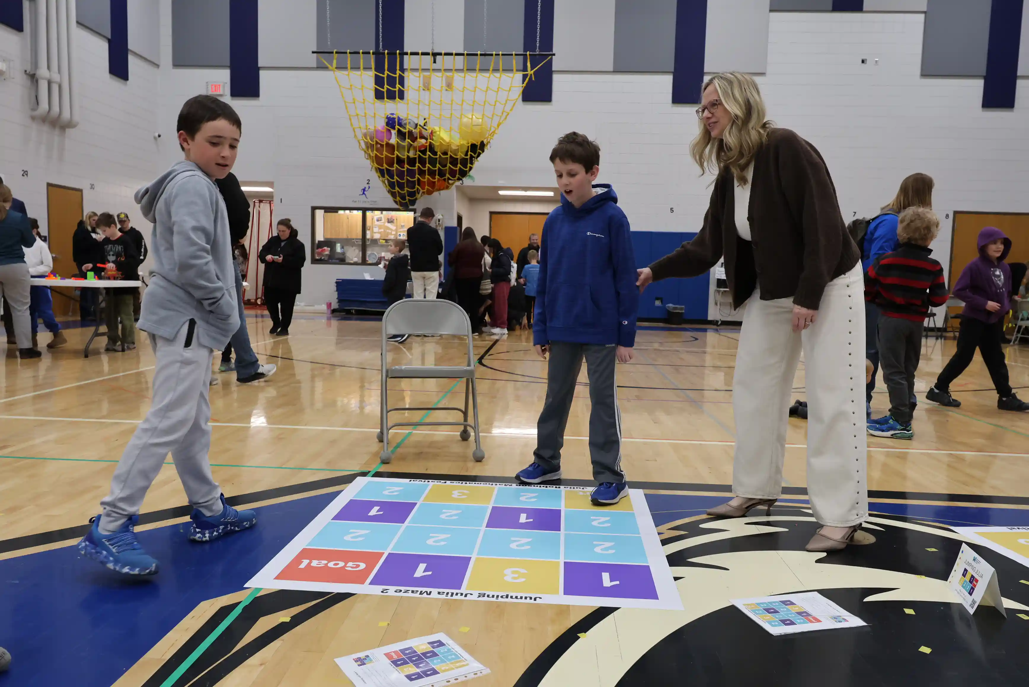 Students walking through a math chart game on the floor