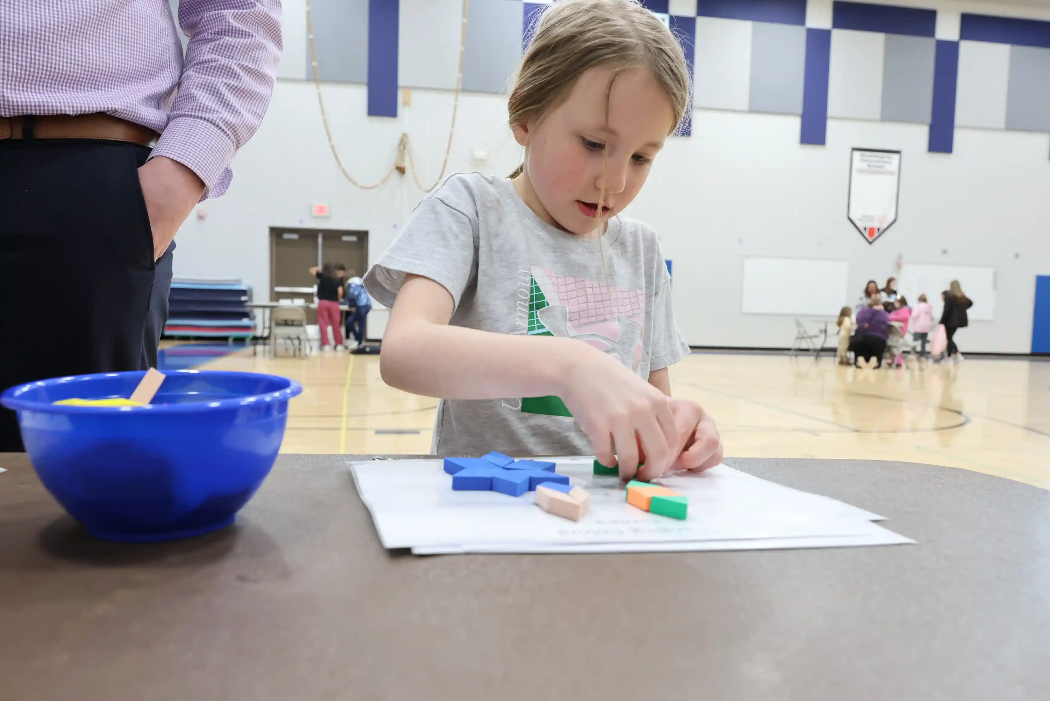 student working on shapes at a table