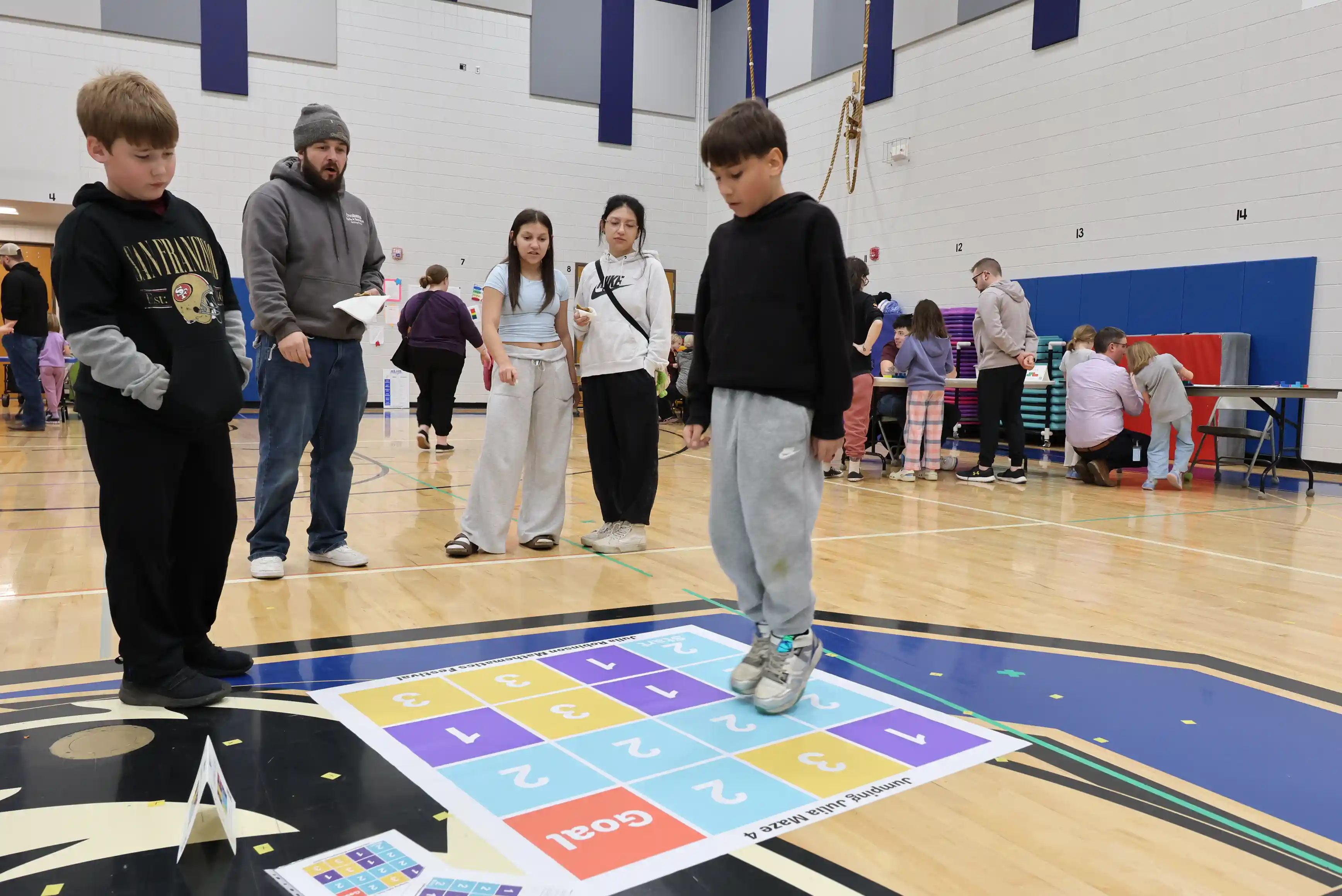 Students walking through a math chart game on the floor