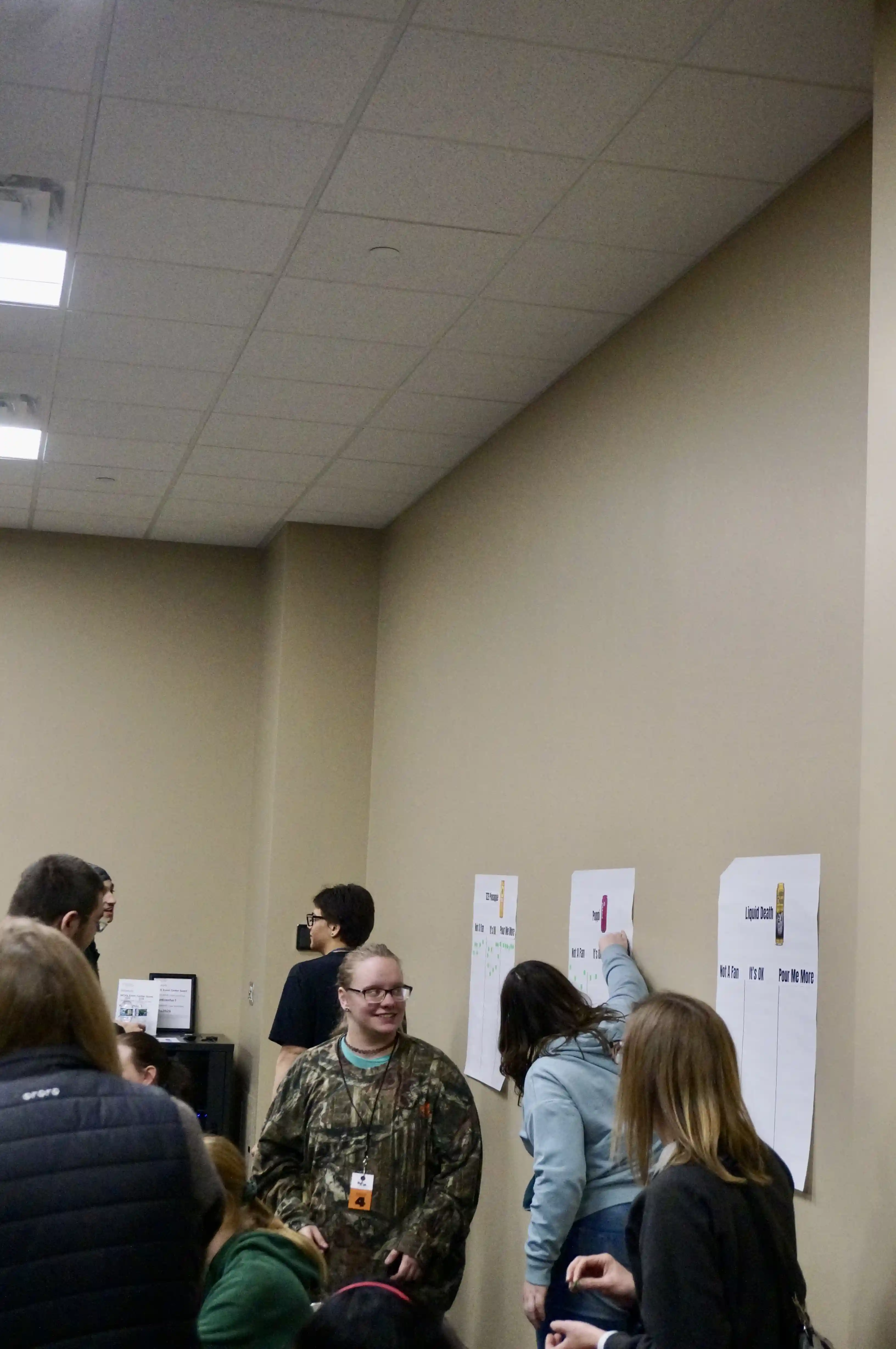 Students walking around a room looking at different table stations