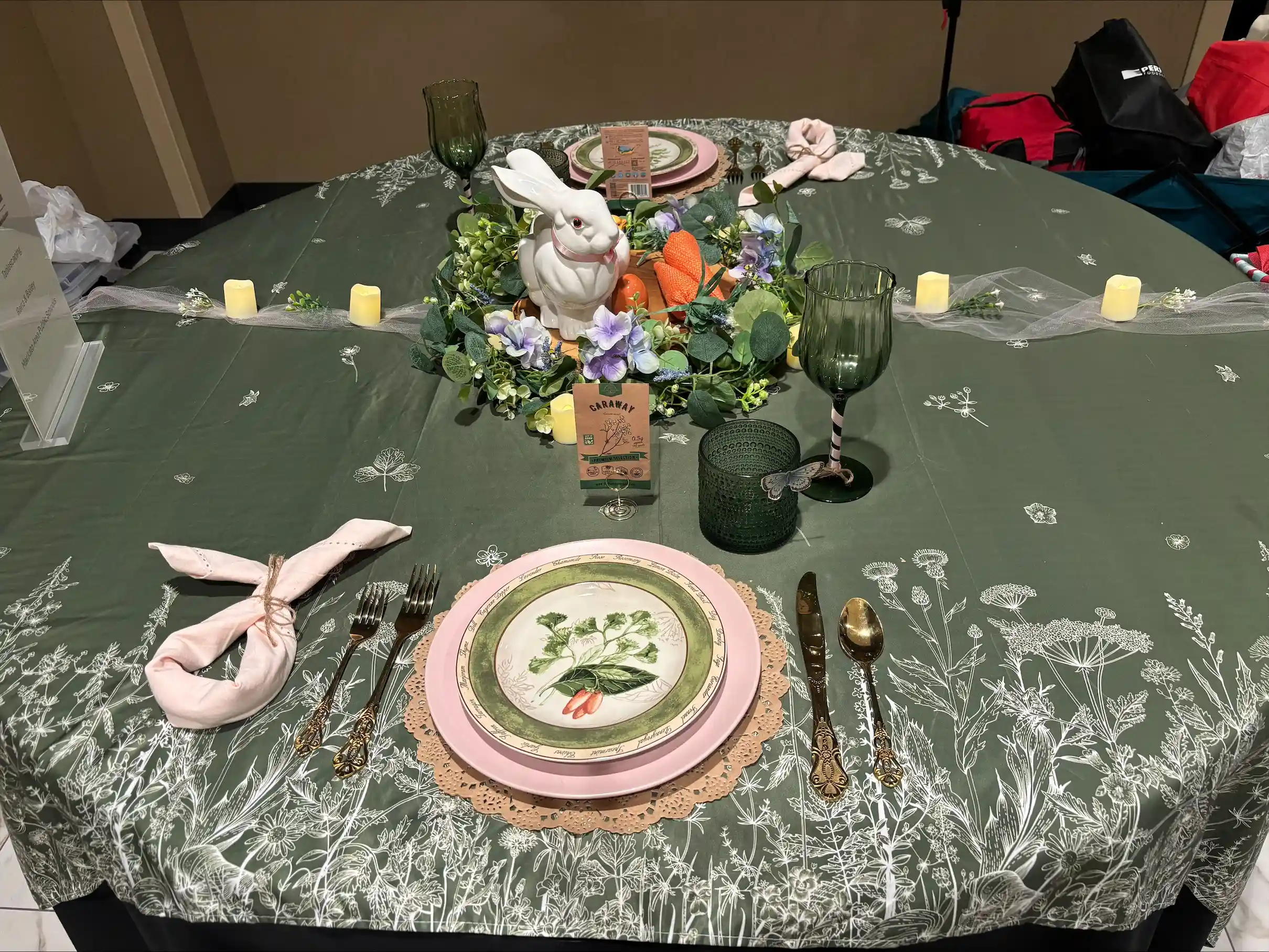 table set nicely with green table cloth and plate and silverware