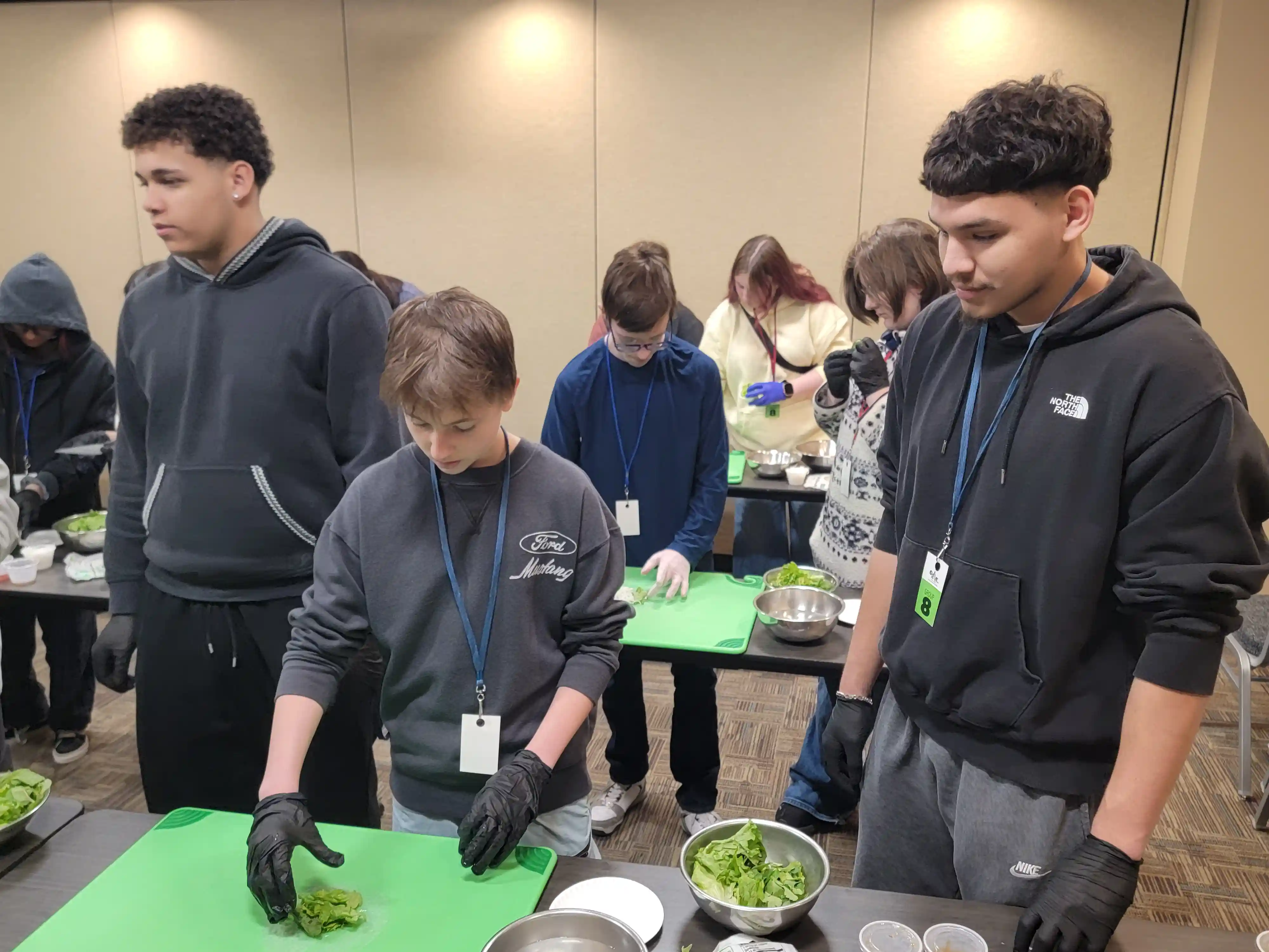 students at tables preparing food