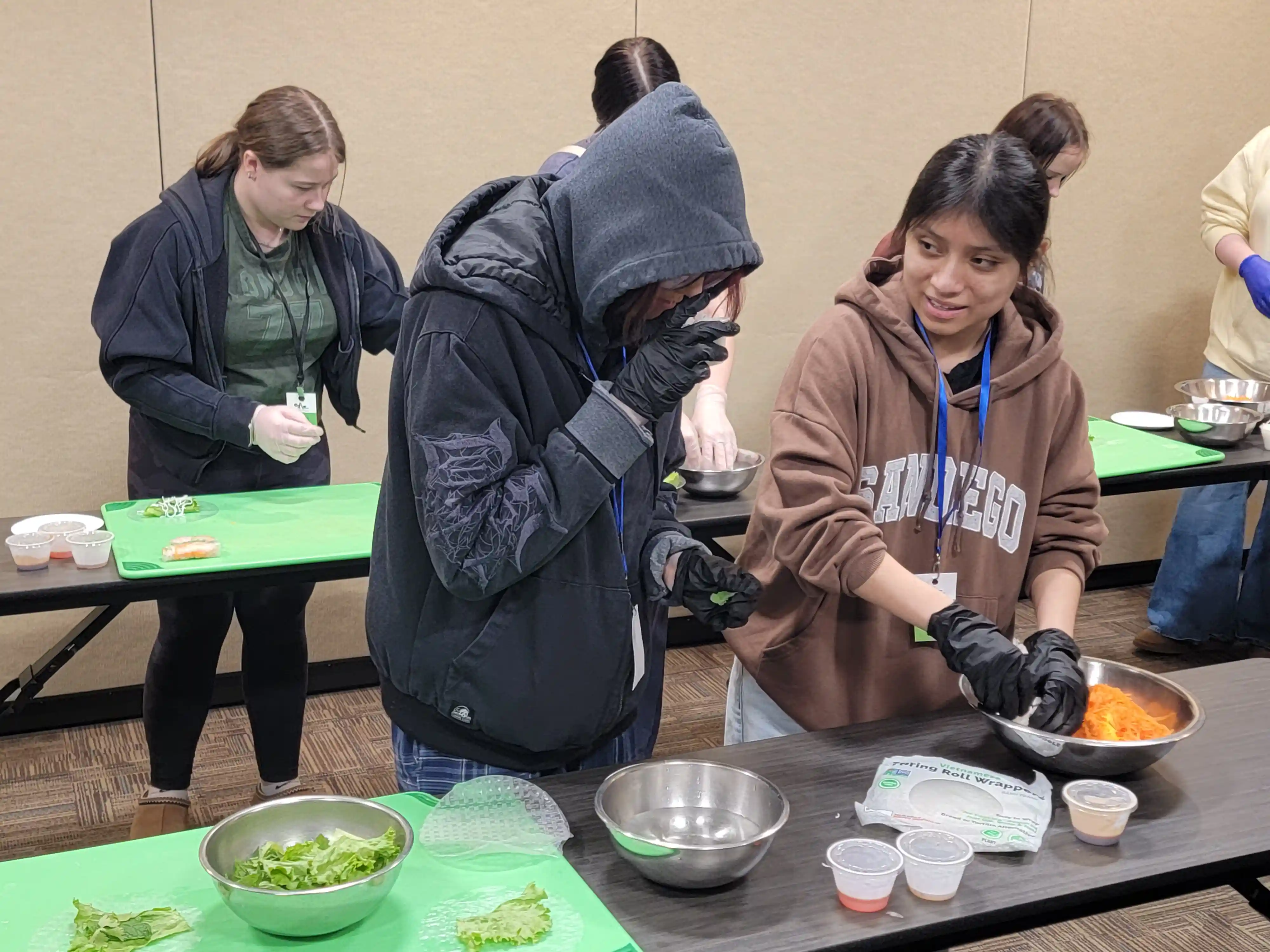 students at tables preparing food