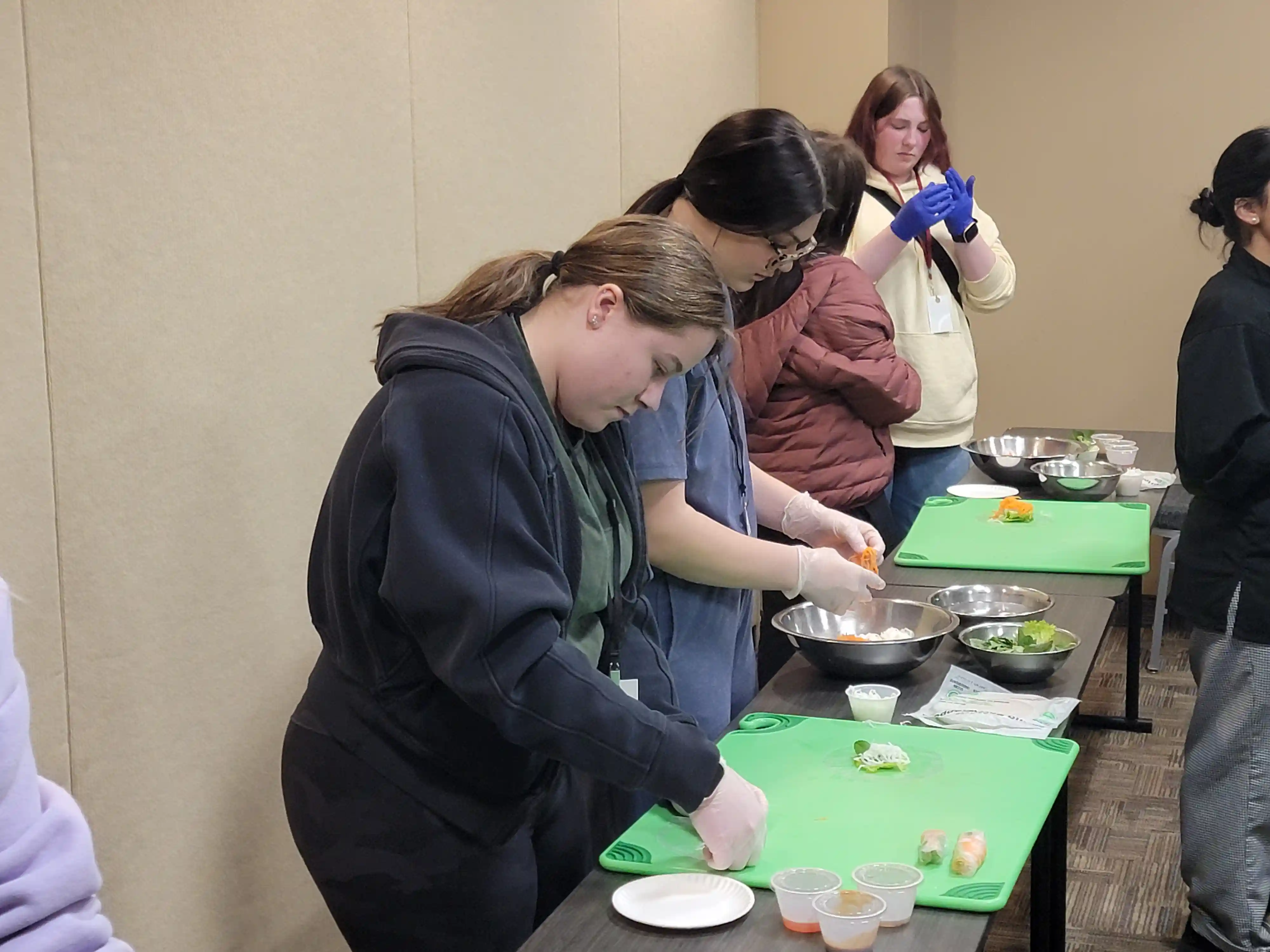 students at tables preparing food