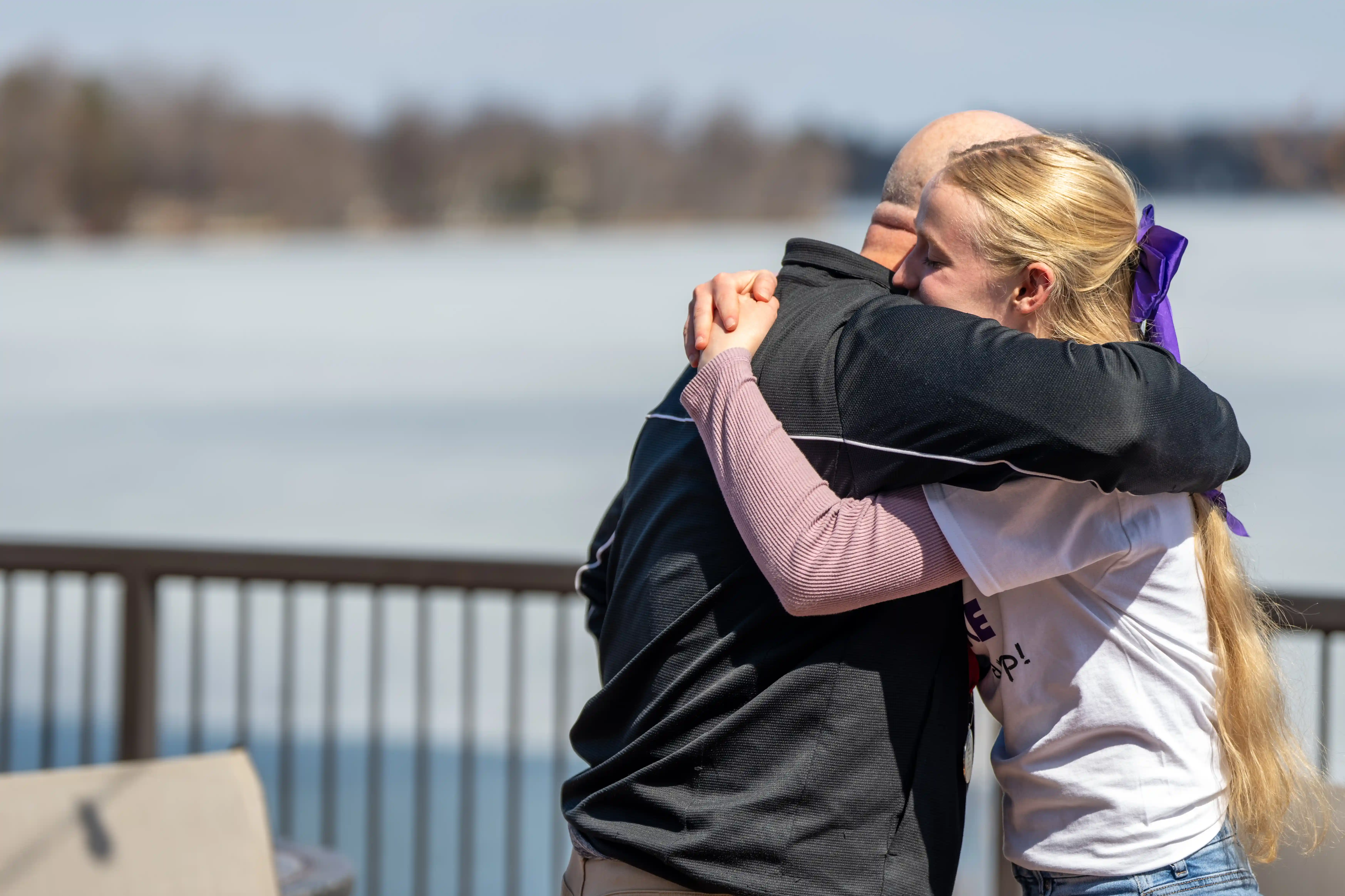 student and adult hugging after competition