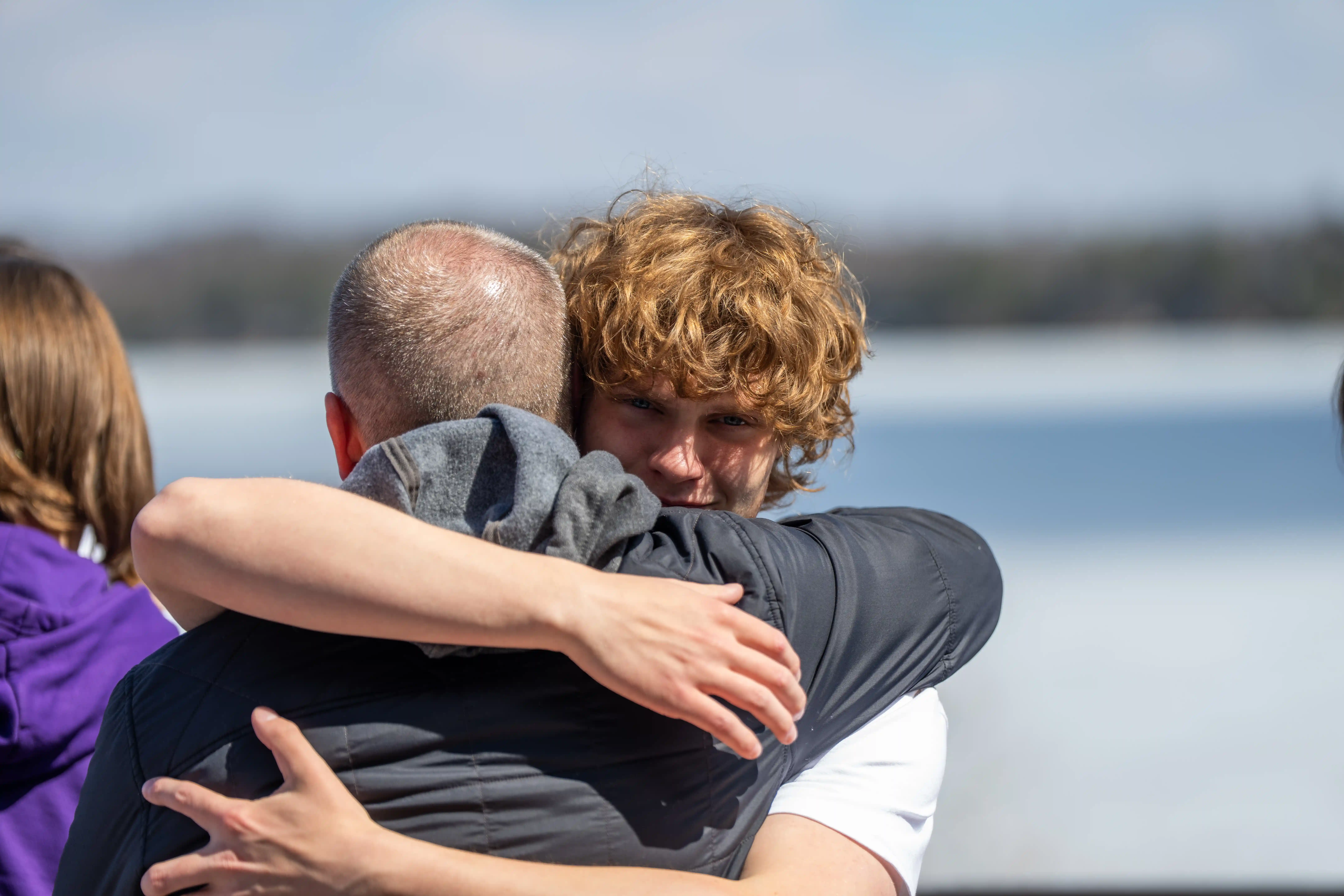 student and adult hugging after competition