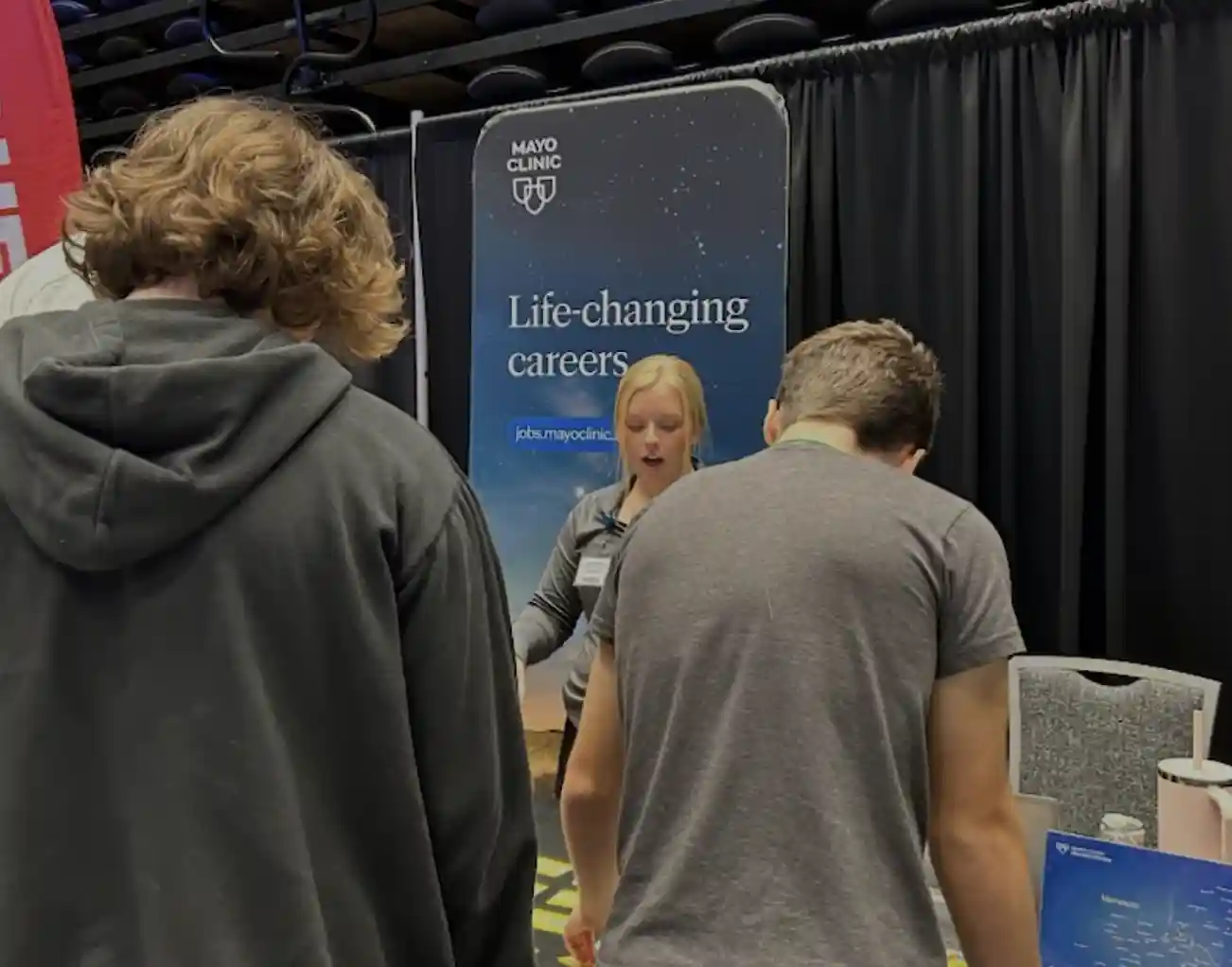 students at a career booth talking to an adult