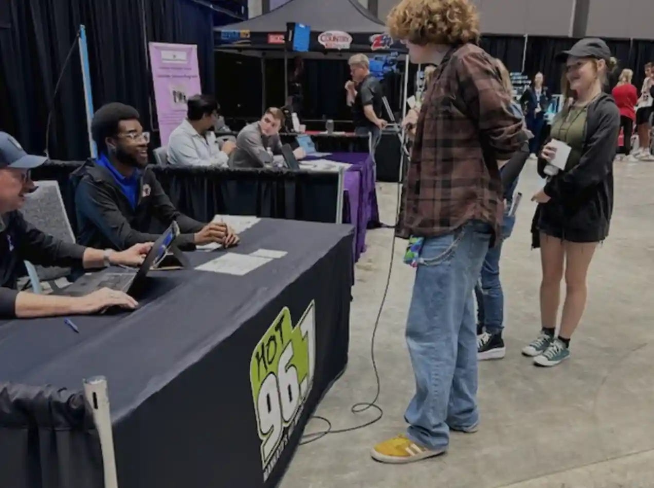 Students by career booth talking to an adult